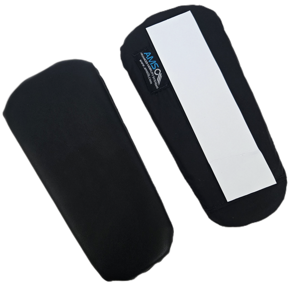 Two black padded object covers or cases, one with a blank white rectangular label on top, likely for medical or protective purposes.
