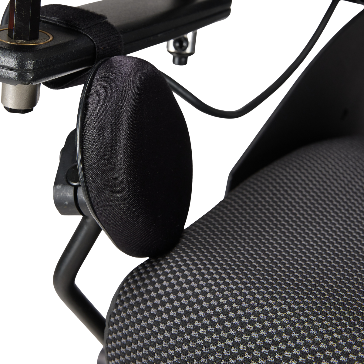 Close-up of an office chair with a textured, black and gray patterned seat, and a black fabric headrest.