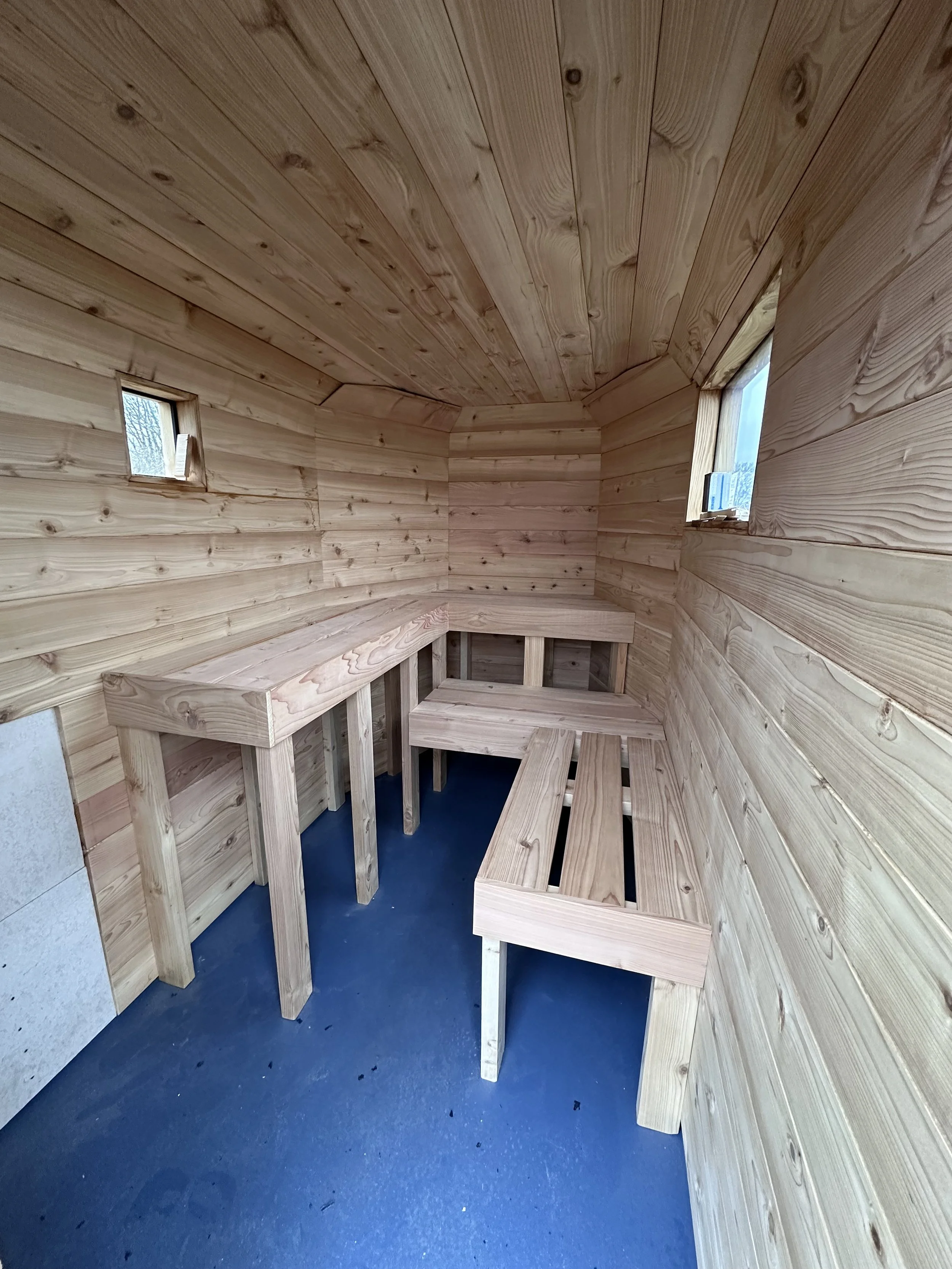 An interior shot of the Drift Sauna, made from Cedar, including the sauna benches, floor, walls, celing and windows during construction.
