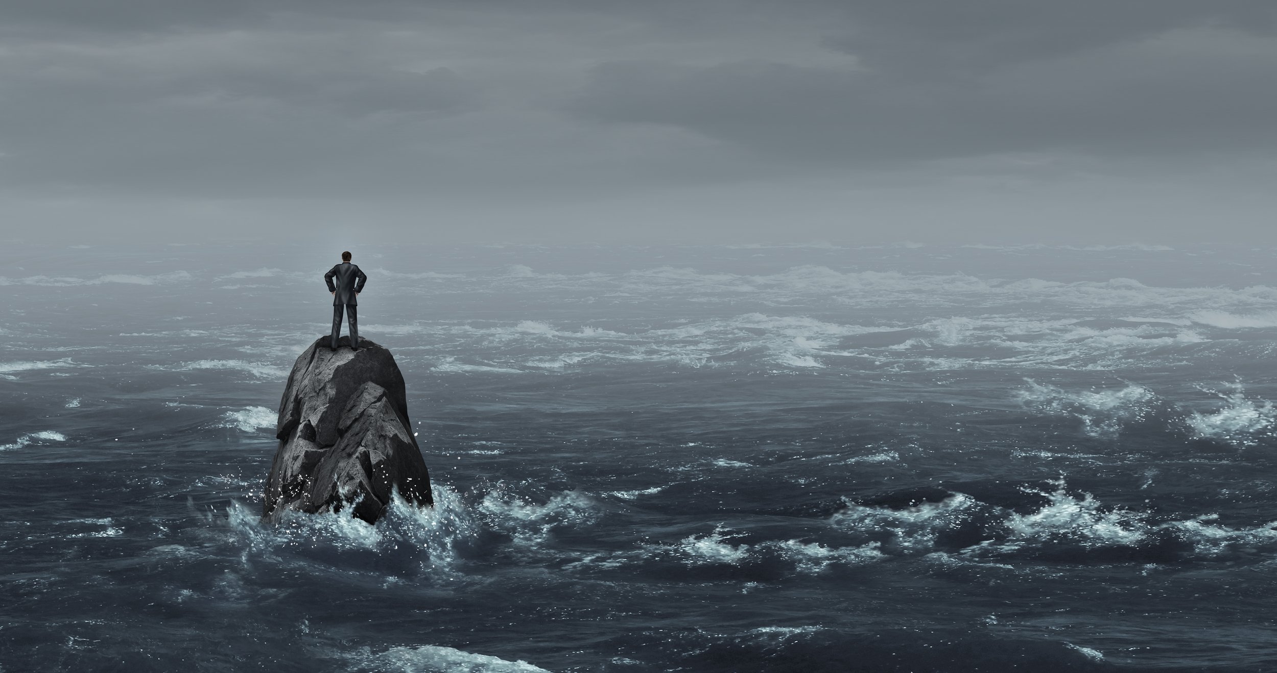 Image of a businessperson standing on a rock in the middle of a stormy ocean