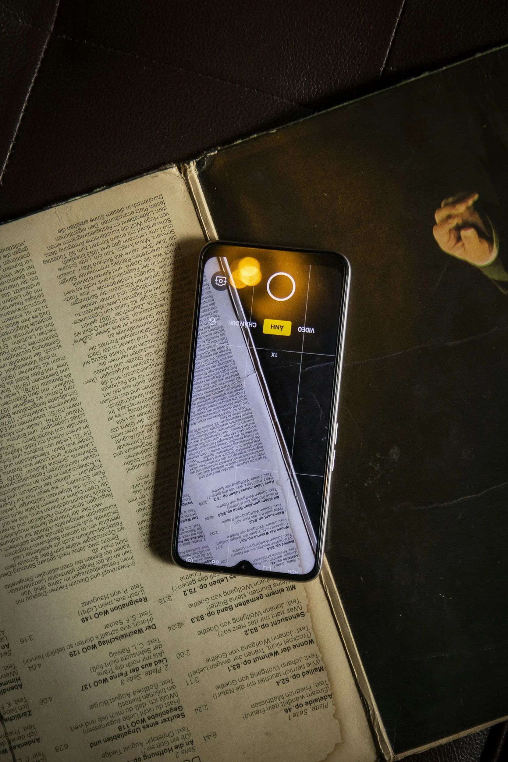 open book with an iphone taking a picture of the pages