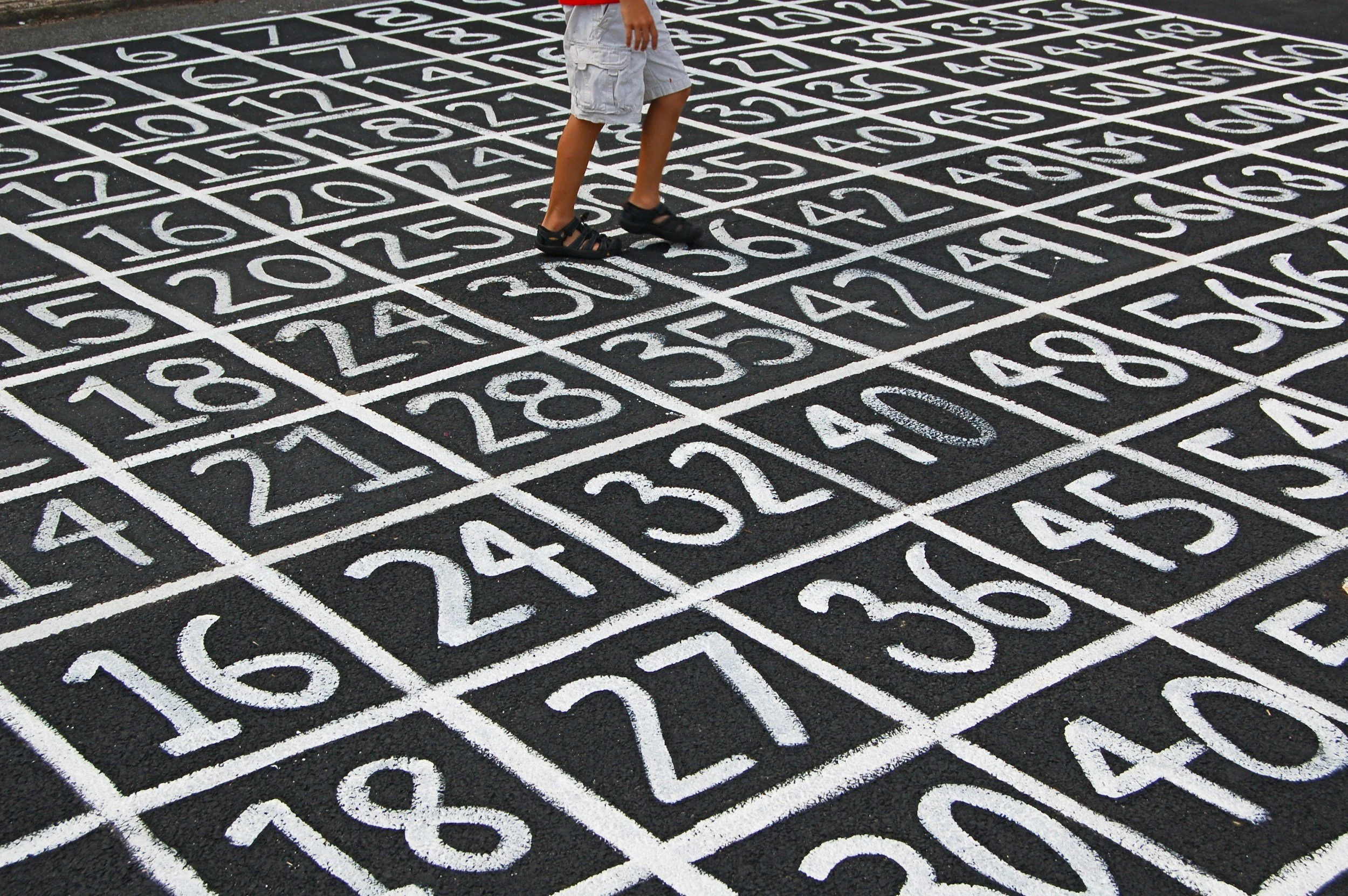 child walking across a number block child is small compared to the amount of numbers