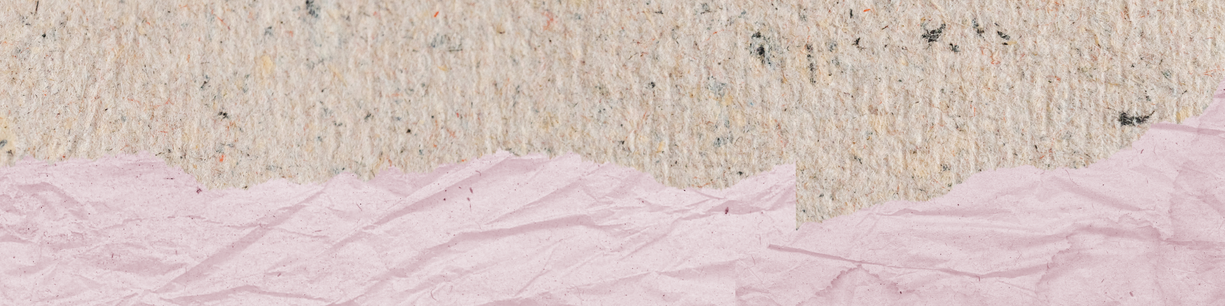 Close-up of torn pink paper layered over a textured, speckled surface.