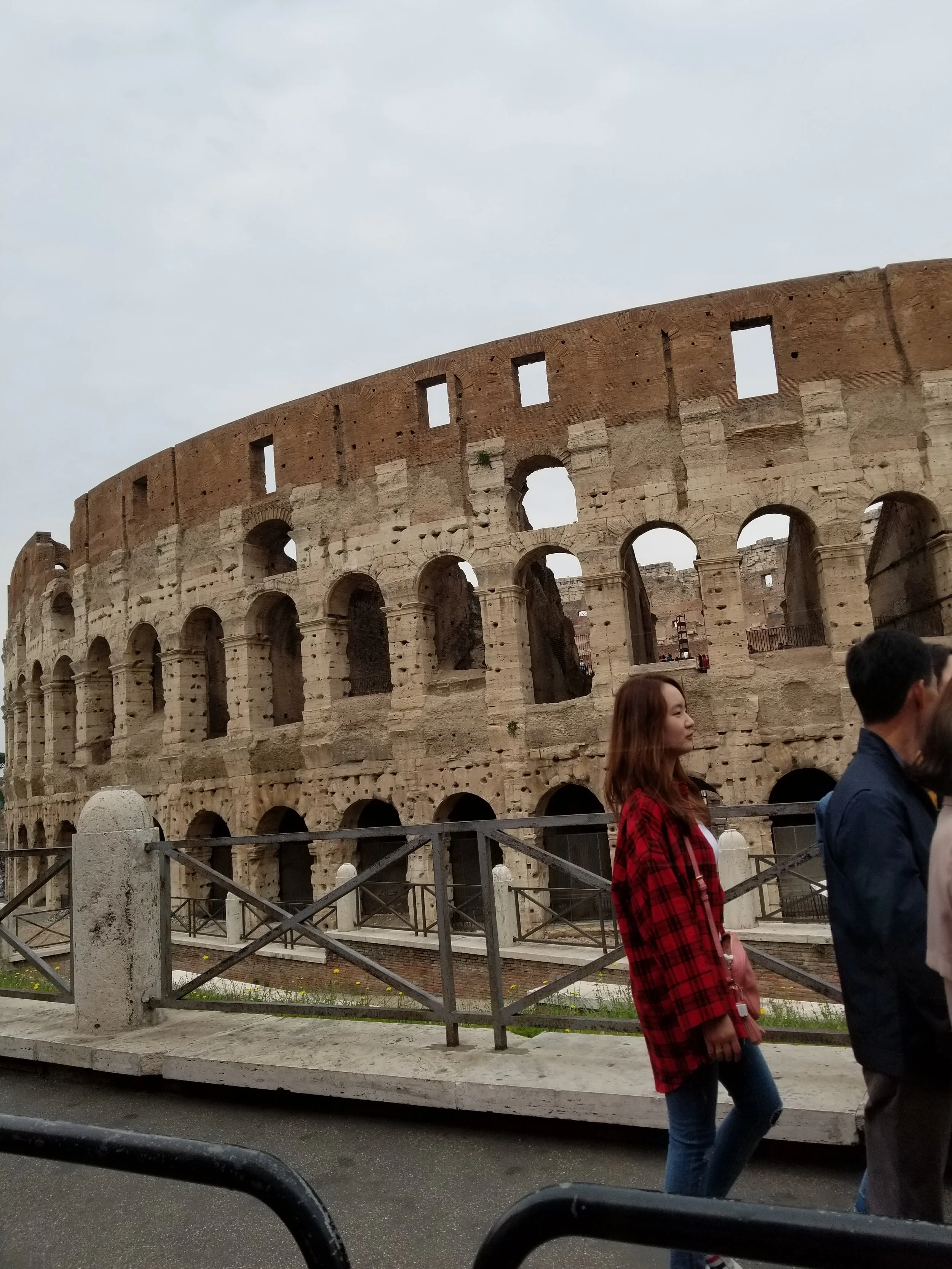The Colosseum in Rome, Italy, with tourists walking in front of it.