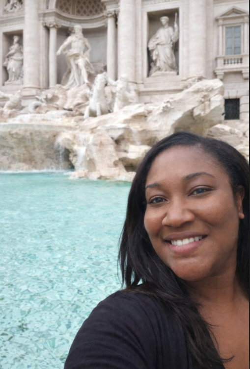 A woman taking a selfie in front of the Trevi Fountain in Rome, Italy.