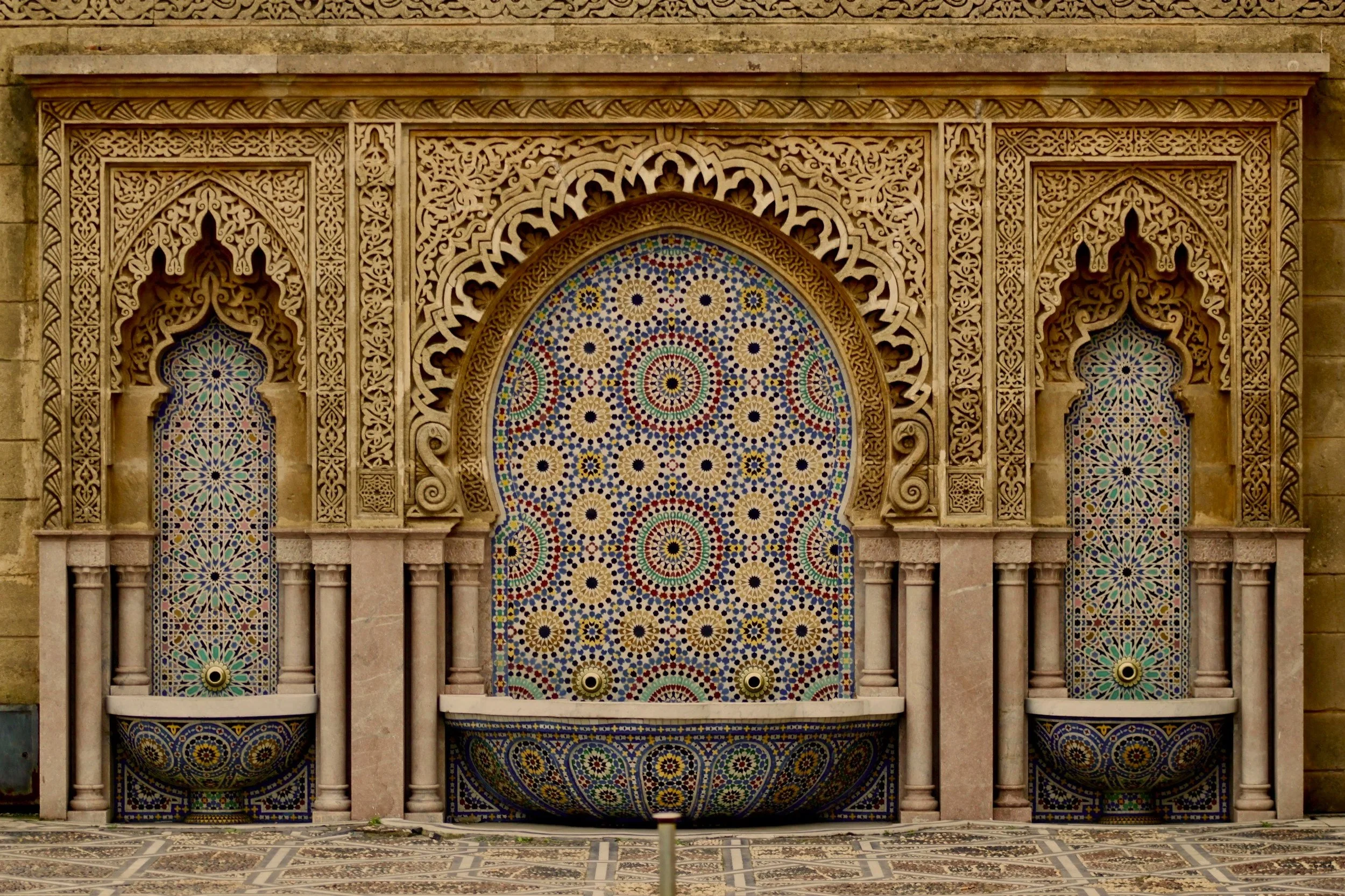 Decorative water fountains with colorful mosaic patterns, ornate arches, and intricate carvings.