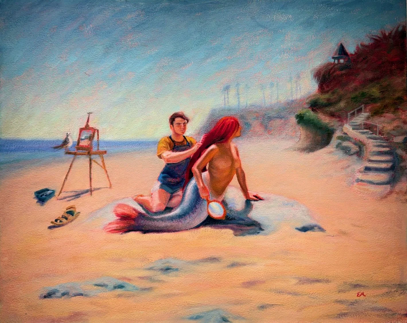 A young man painting a woman with a mermaid tail on the beach at sunset, with an easel and art supplies nearby and a staircase leading to houses on a hill.