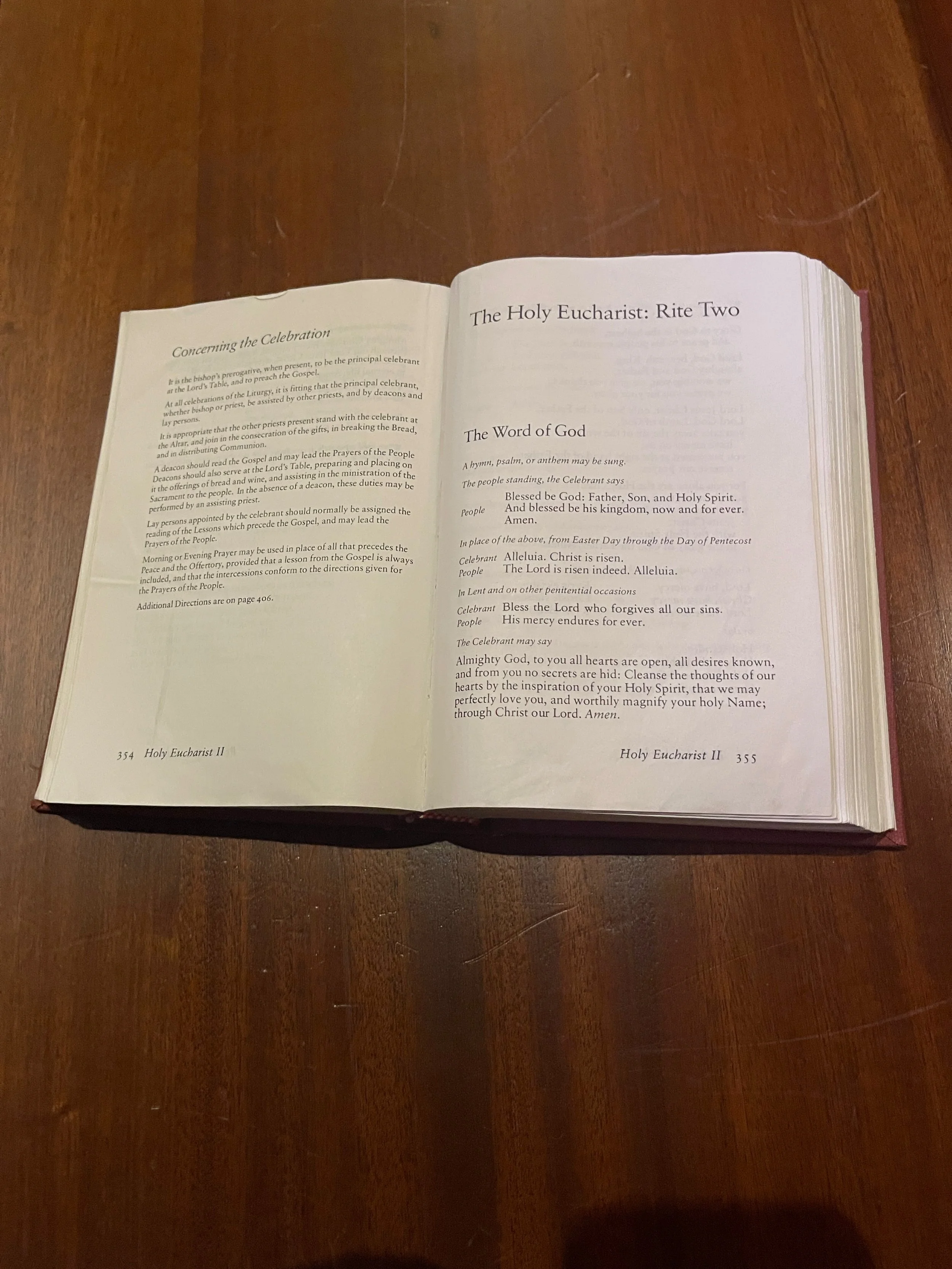 Open religious book on a wooden table, showing pages with prayers and hymns for the Holy Eucharist.