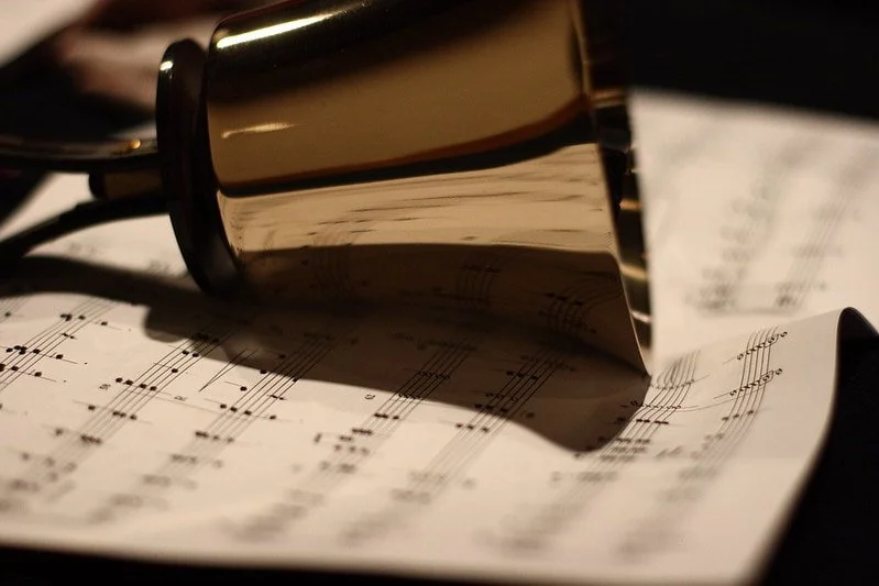 Sheet music with a gold bell resting on top.