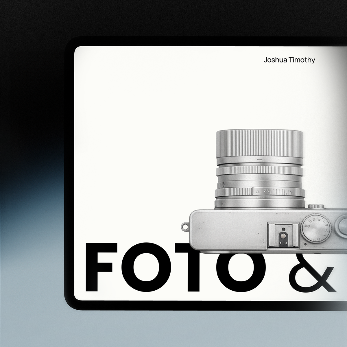 A graphic design featuring a silver camera with a large lens. The background is white with the text "FOTO &" in large black letters, and the name Joshua Timothy in small font at the top right corner.