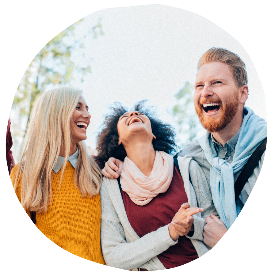 Three people outdoors laughing and enjoying each other's company.