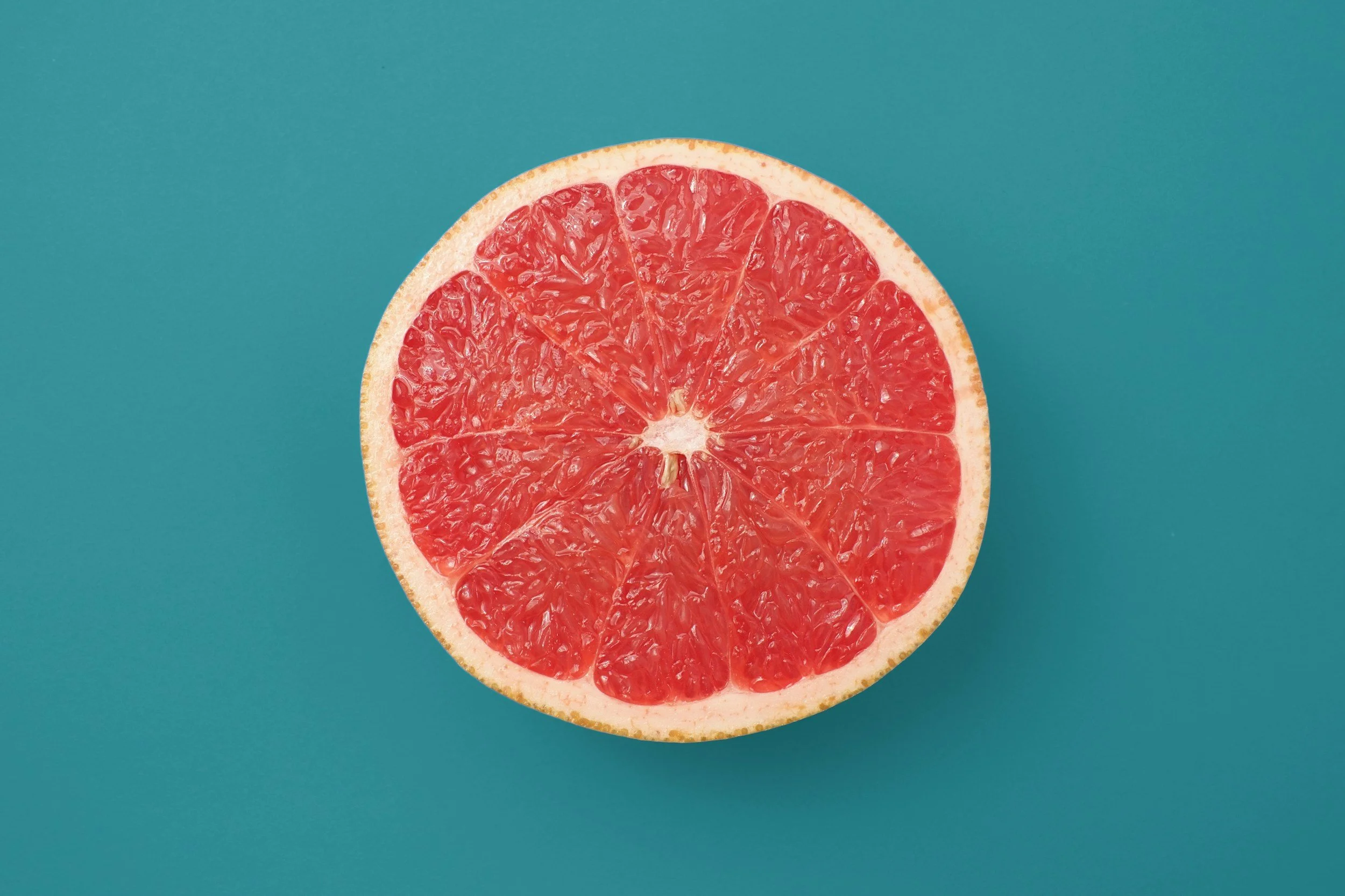 Halbe Grapefruit auf blauem Hintergrund.