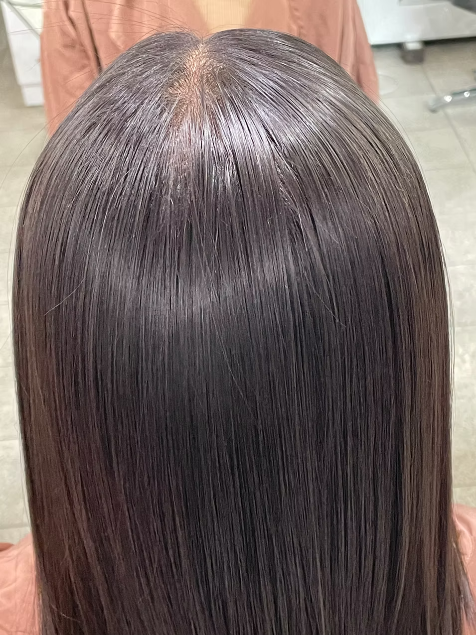Top view of shiny, straight, dark brown hair.
