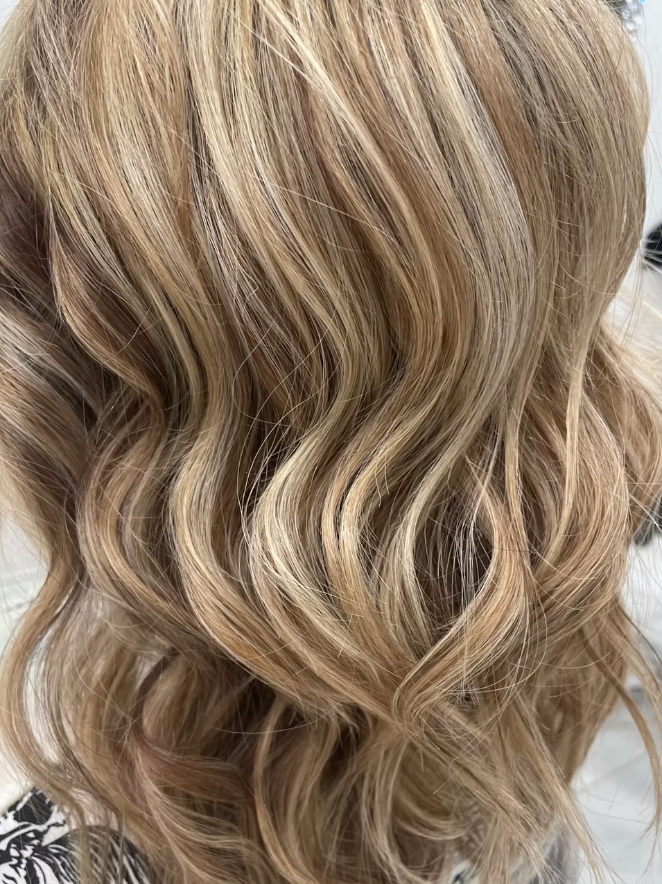 Close-up of wavy blonde hair with highlights.