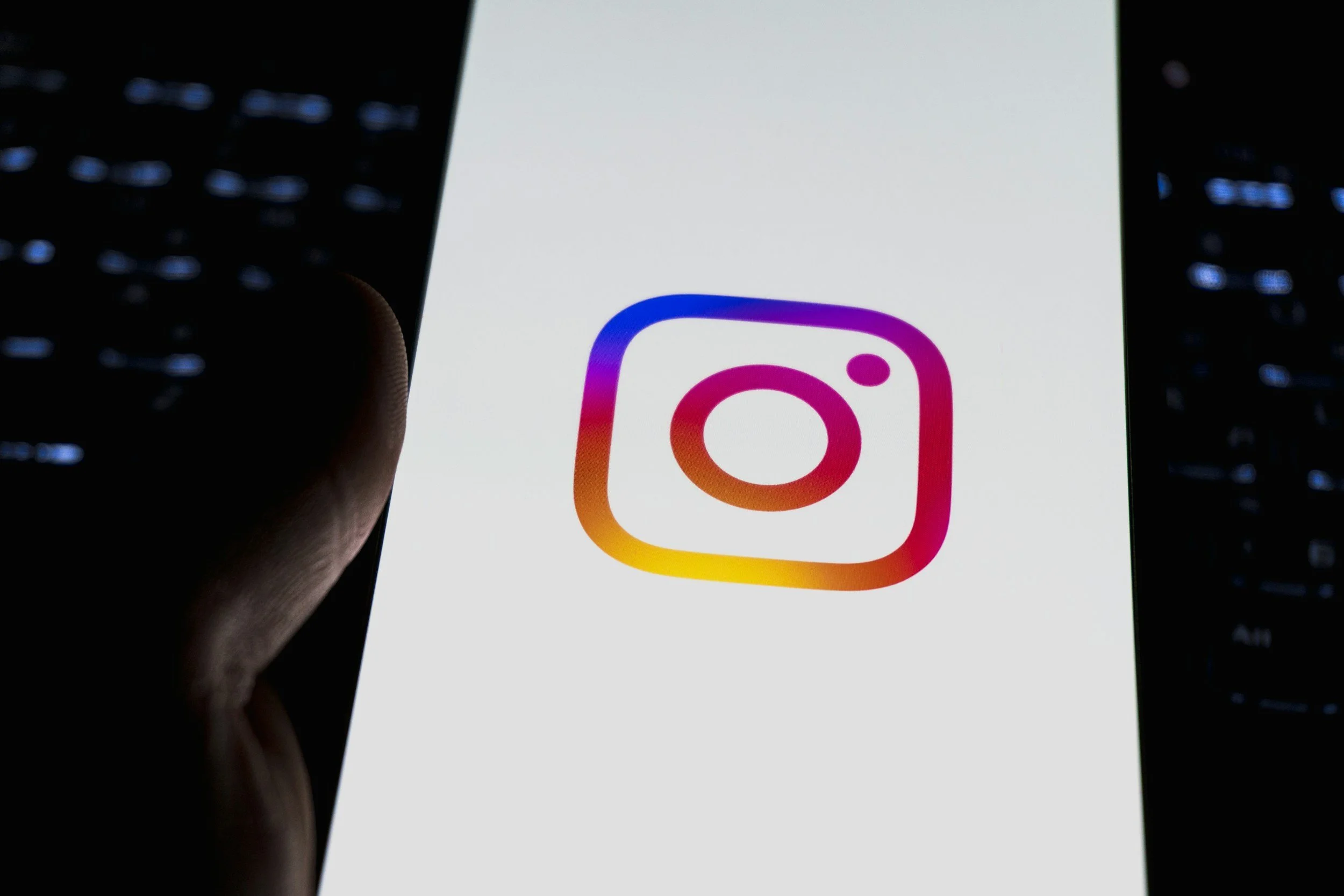 Smartphone screen displaying the Instagram app logo with a black background.