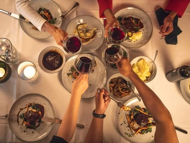 Groupe réuni autour d’un repas et levant leurs verres lors d’une soirée d’entreprise