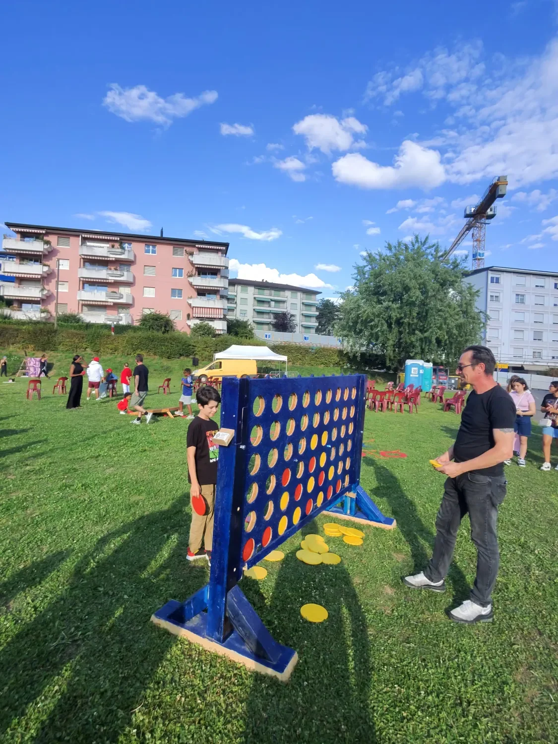Participants jouent à un Puissance 4 géant en plein air lors d’une animation événementielle.