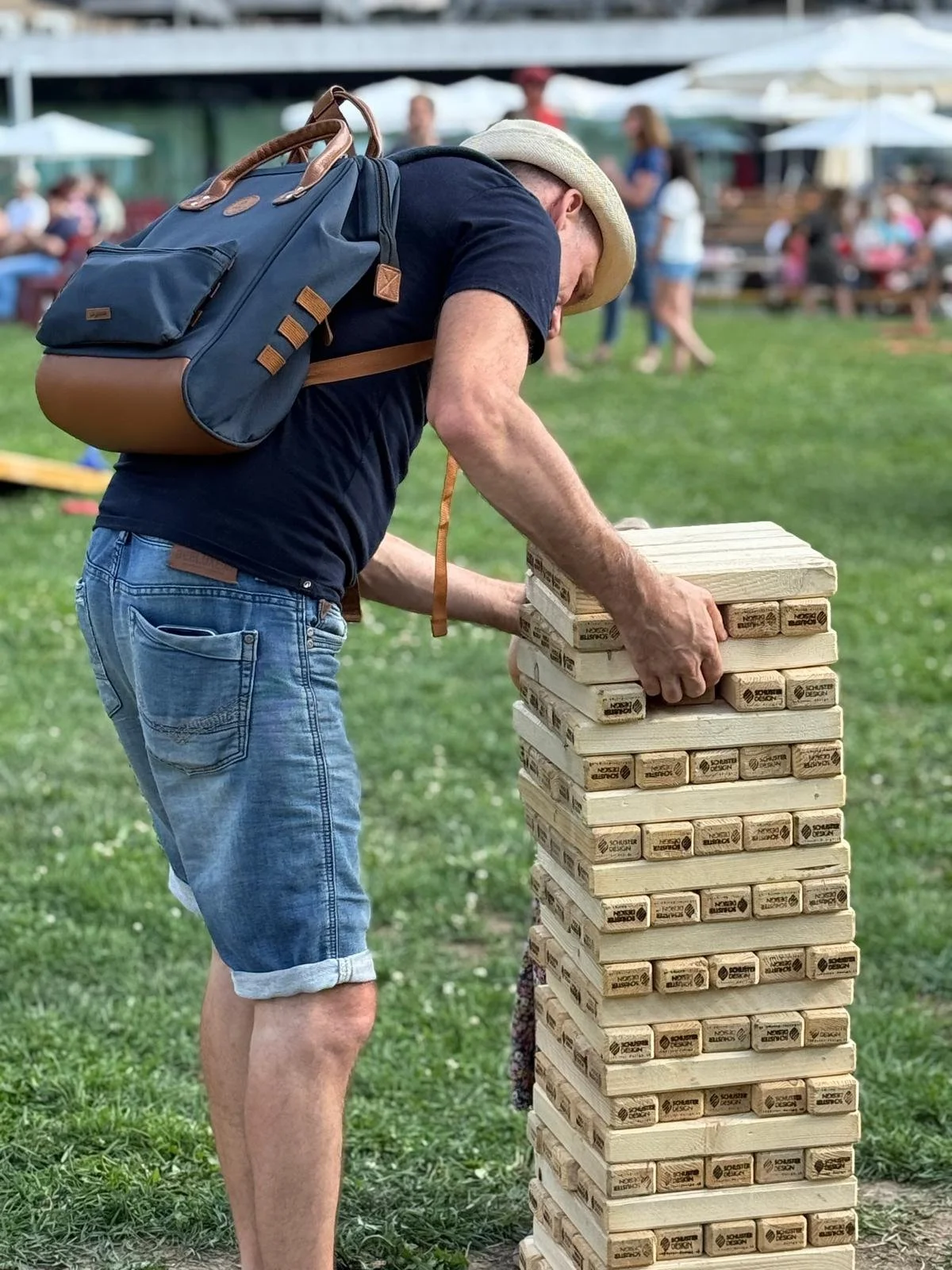 Participant jouant au Jenga géant dans un parc pendant un événement