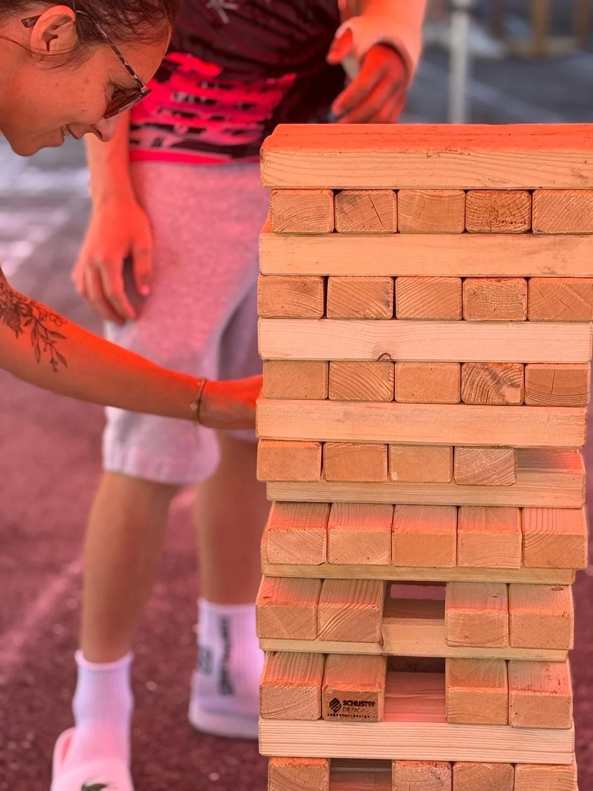 Participante jouant au Jenga géant en plein air