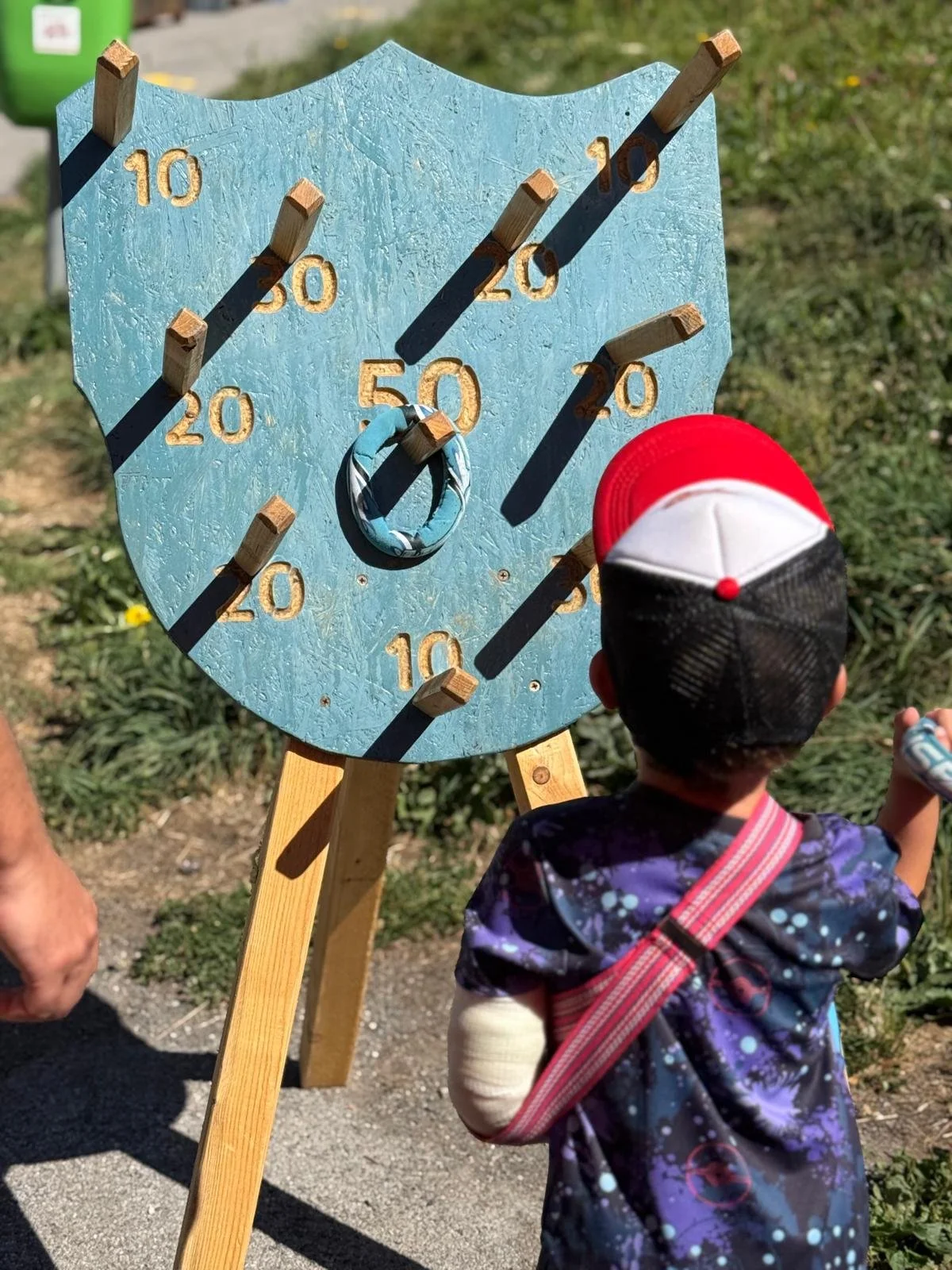 Enfant devant un grand jeu d’anneaux en bois dans une zone d’activités