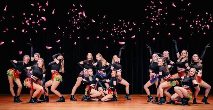 Danseurs se produisant sur scène sous des confettis lors d’un spectacle