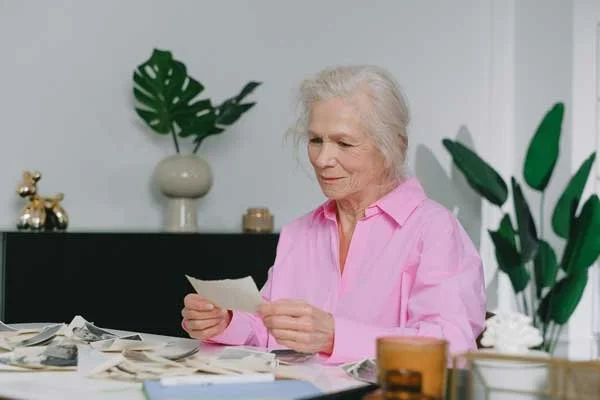 A woman is looking over photos from her family's photo collection.