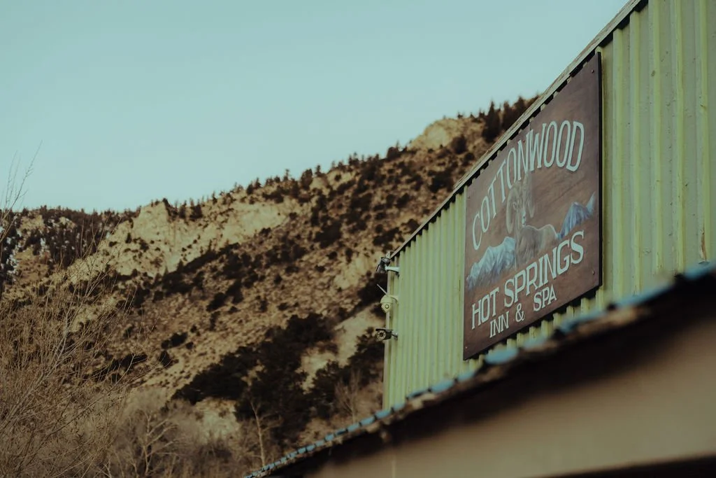 Sign for Cottonwood Hot Springs Inn & Spa with mountains in the background.