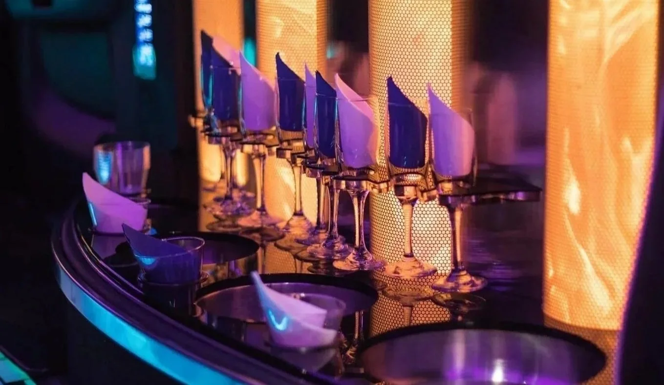 Champagne flutes lined up inside a luxury SUV with ambient lighting