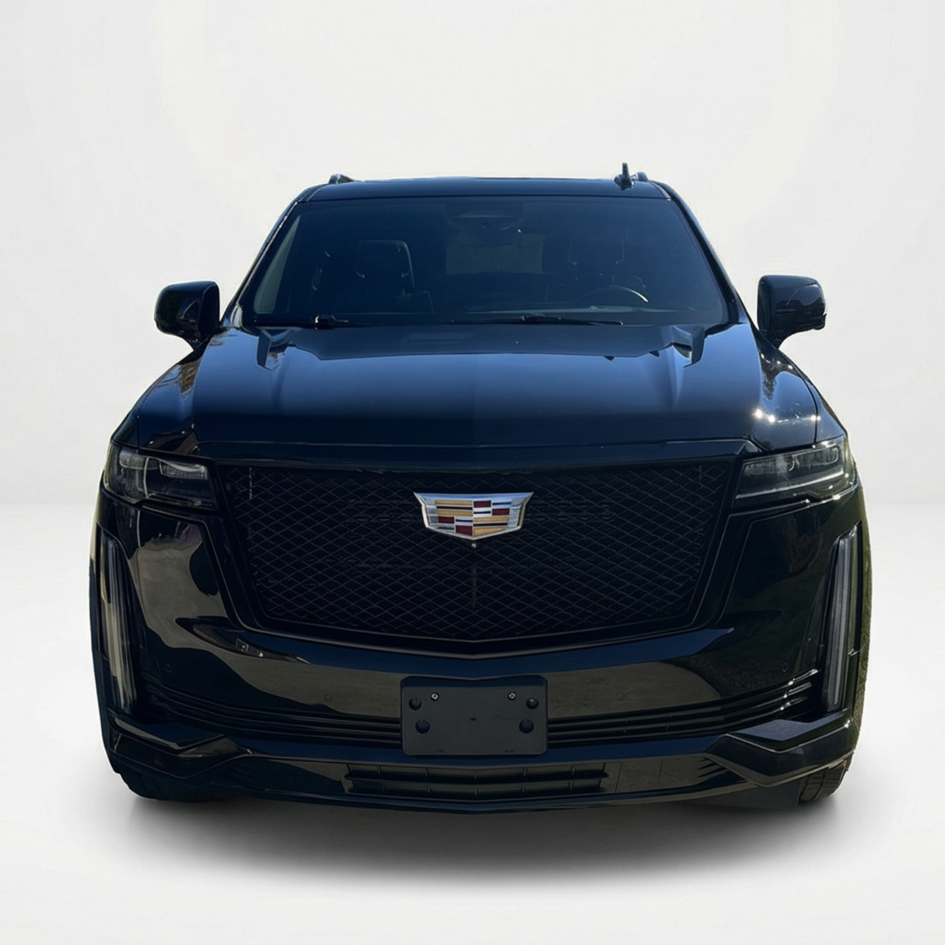 Front view of a 2023 black Cadillac Escalade Sport in an all-white studio setting