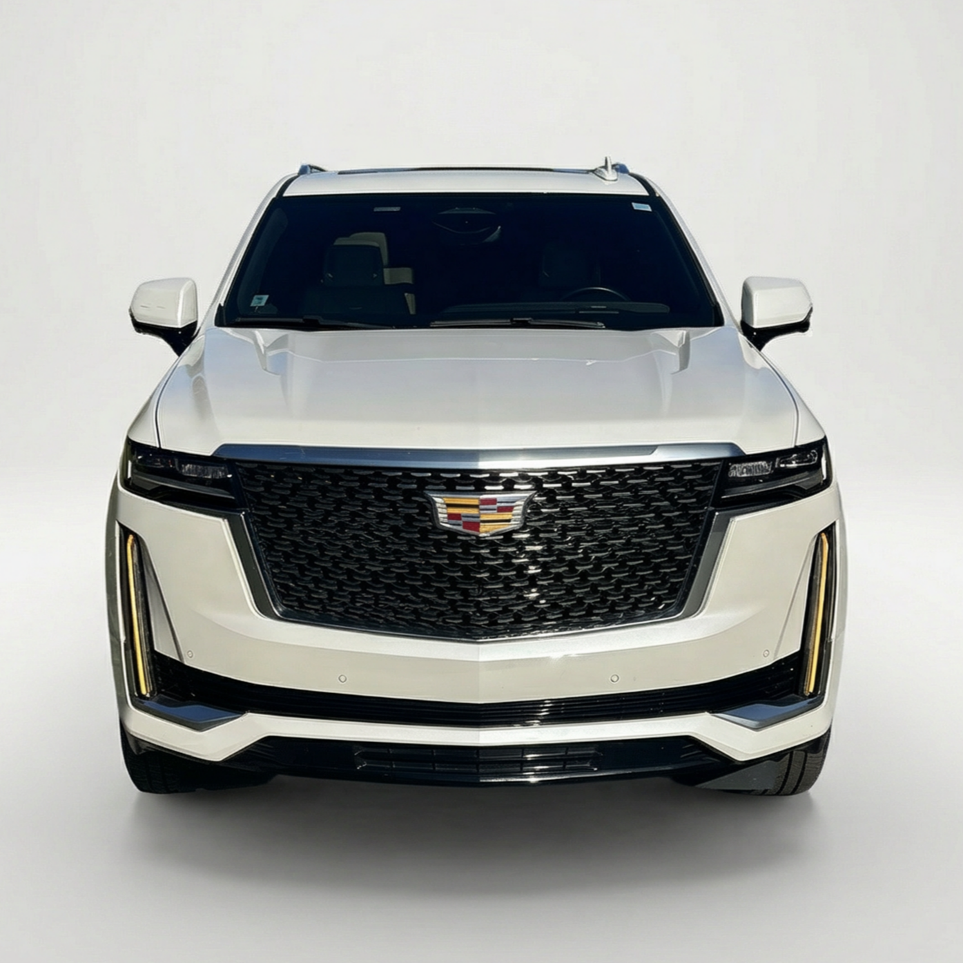 Front view of a 2022 white Cadillac Escalade in an all-white studio setting