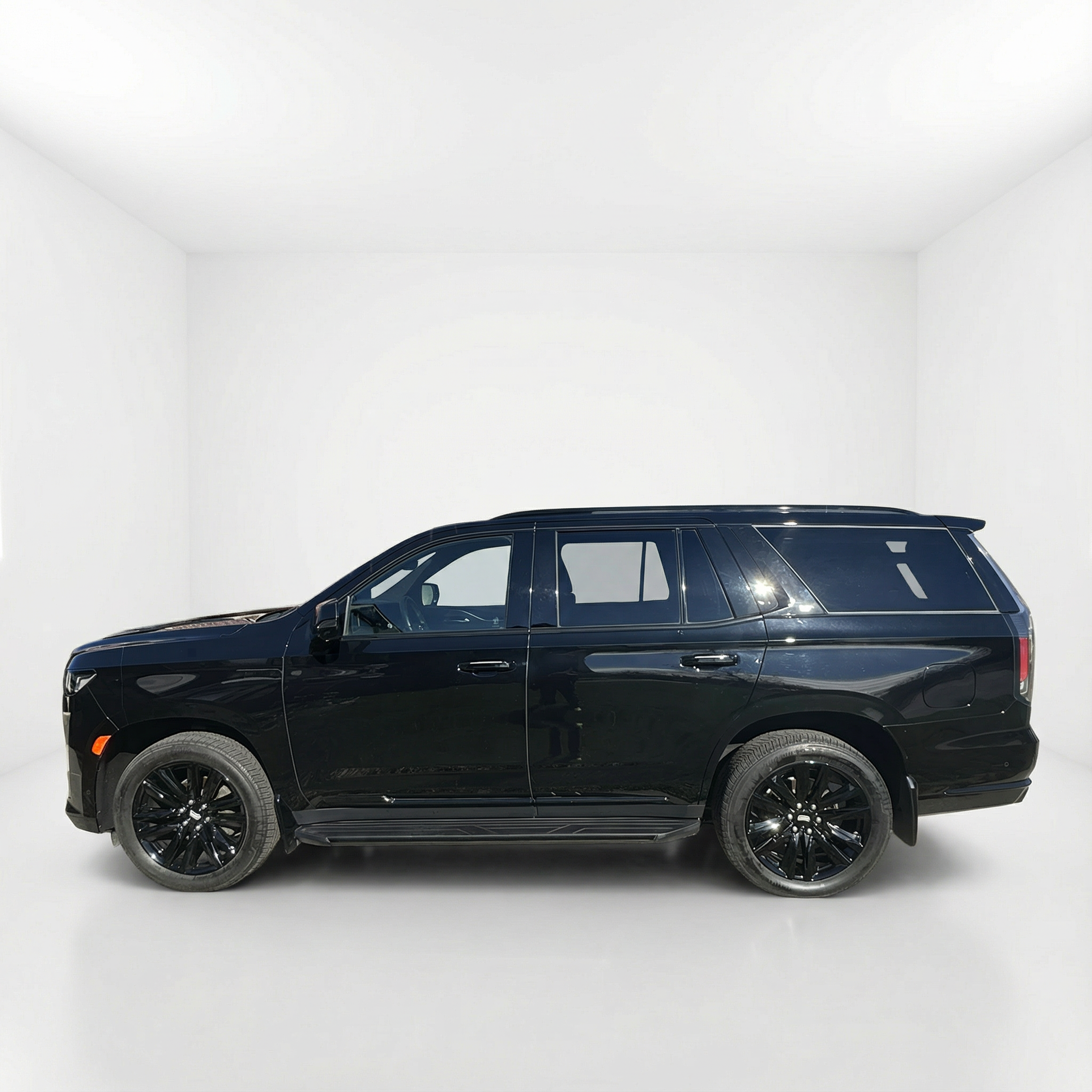 Side profile of a 2023 Cadillac Escalade Sport in an all-white studio setting