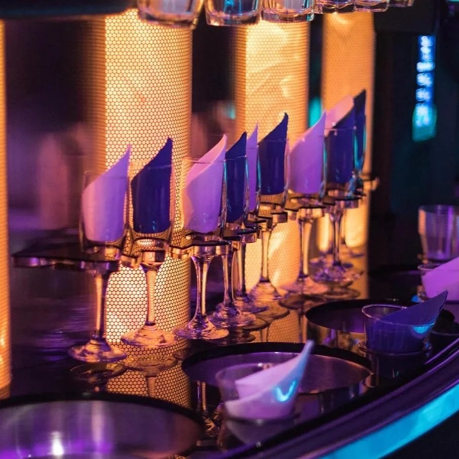 Champagne flutes lined up inside a luxury SUV with ambient lighting