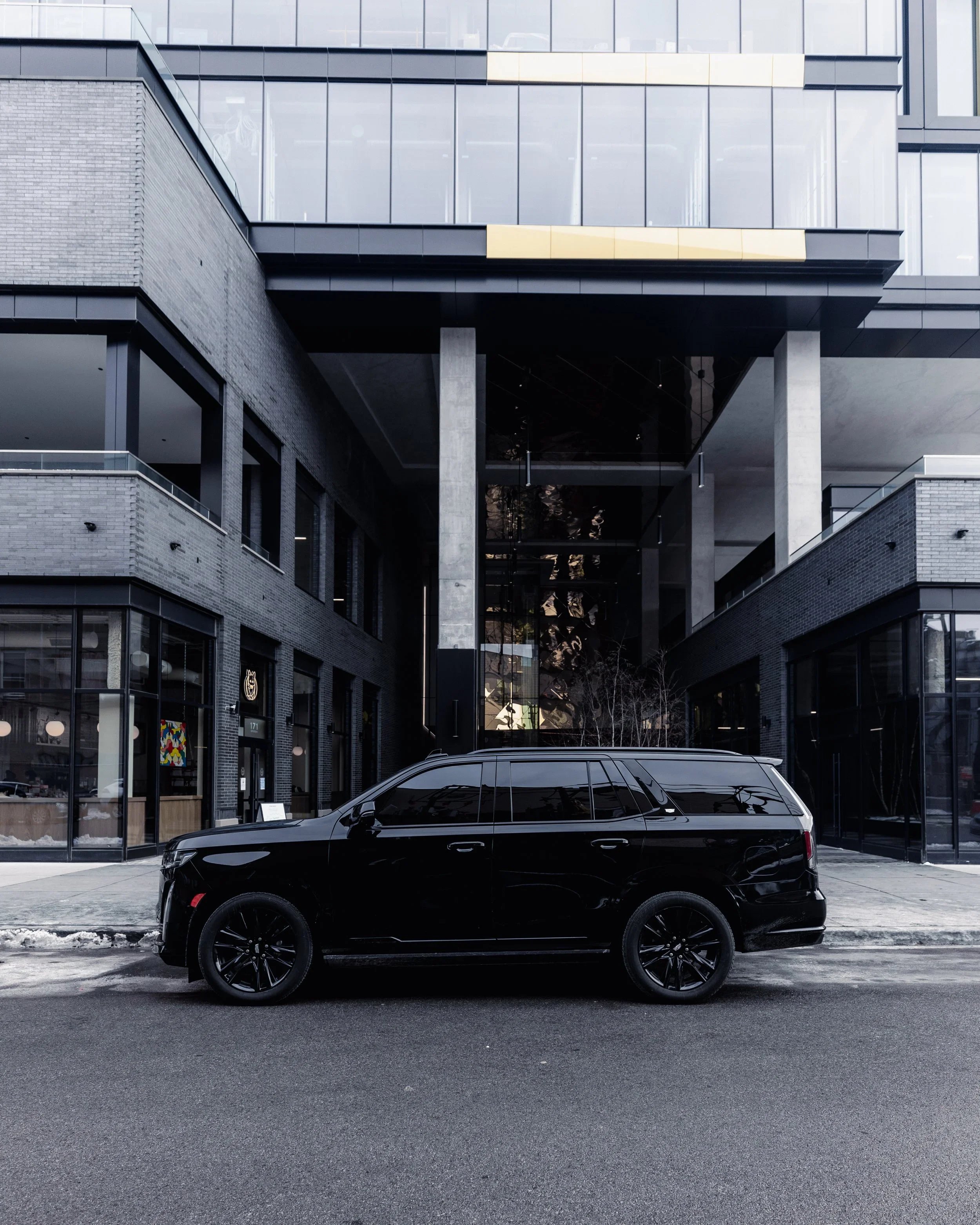 Black luxury SUV parked outside an uptown mixed-use corporate center