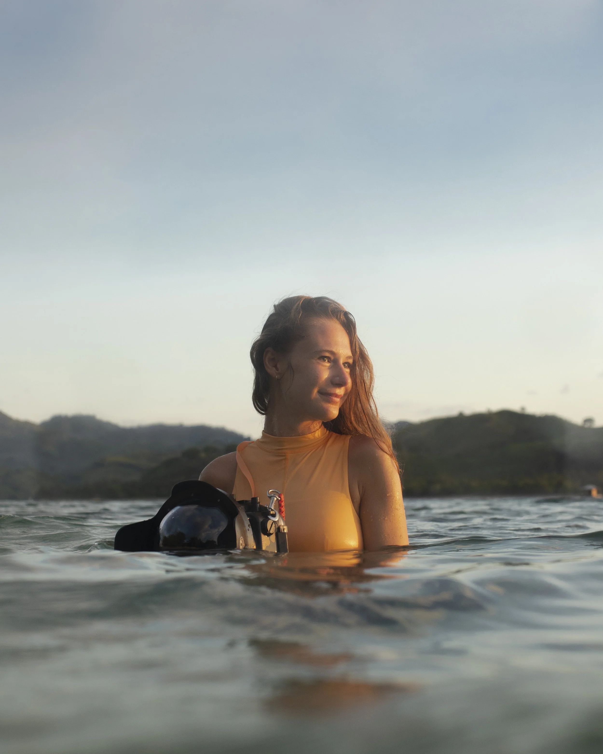 The picture shows Alina Reinisch with her camera in her hands in the ocean, ready to take underwater content.