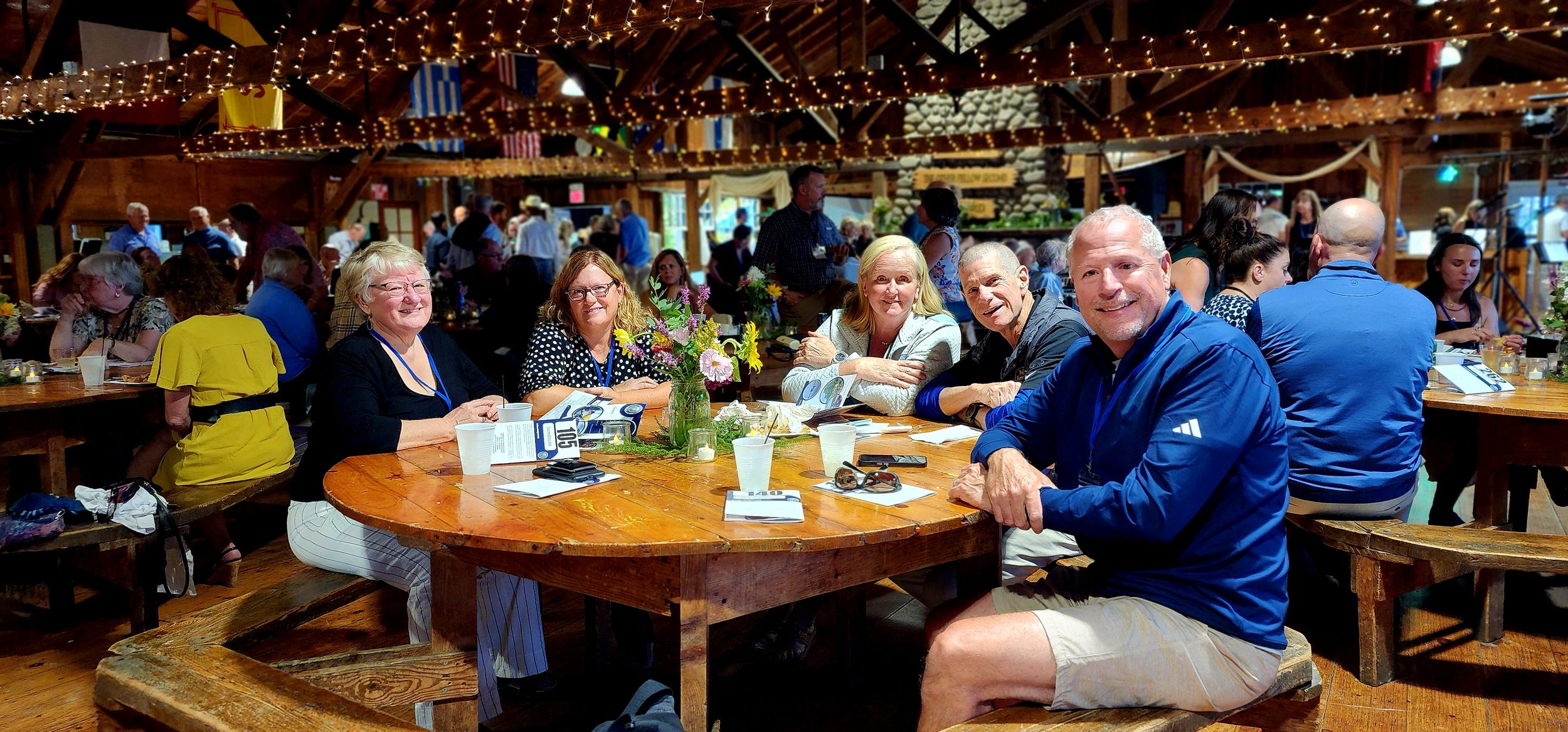 Five people sitting around a table smiling at the camera