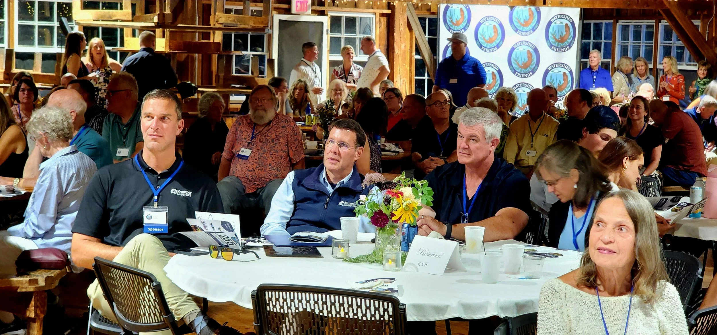 People sitting at a table watching something off camera