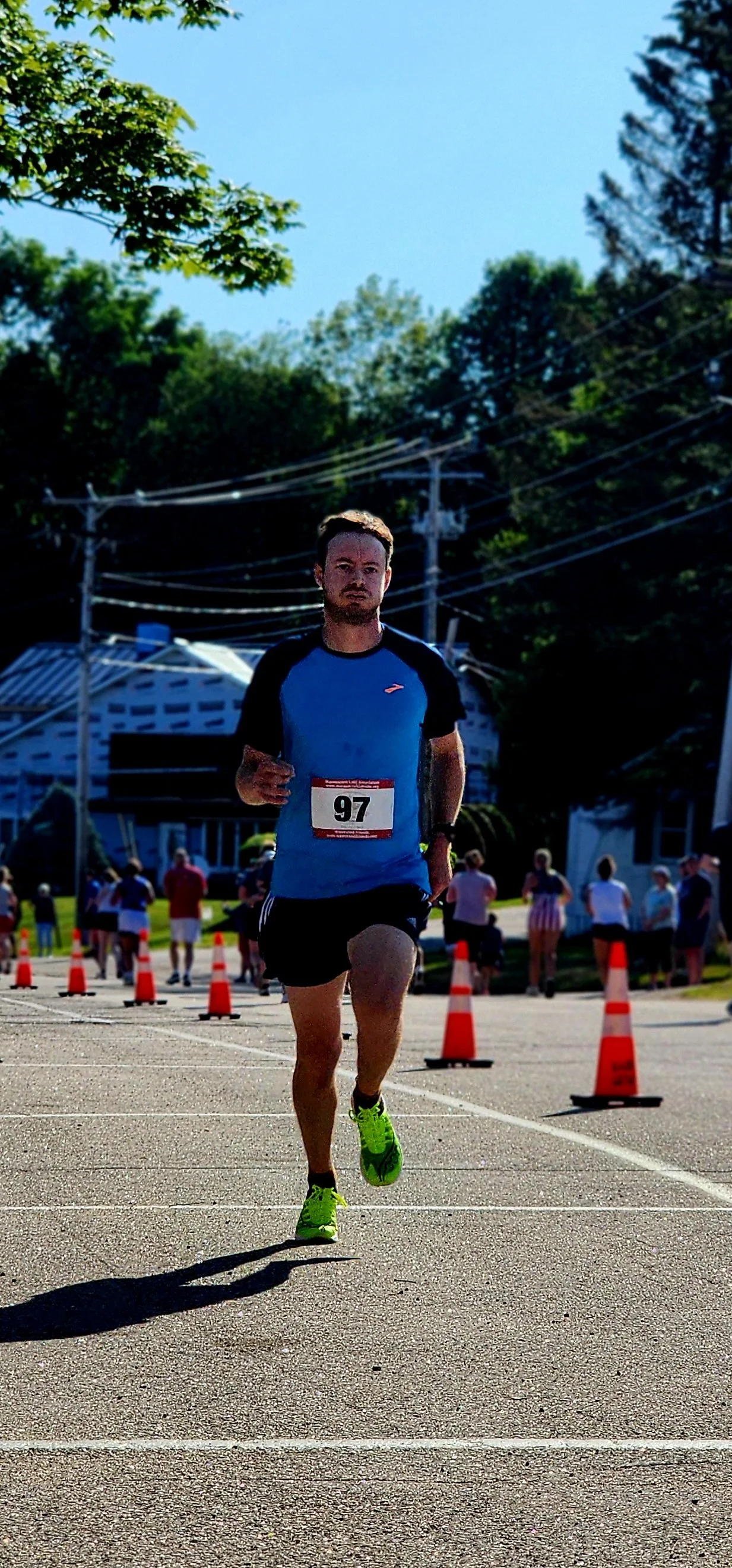 A man wearing a blue t-shirt and black shorts running