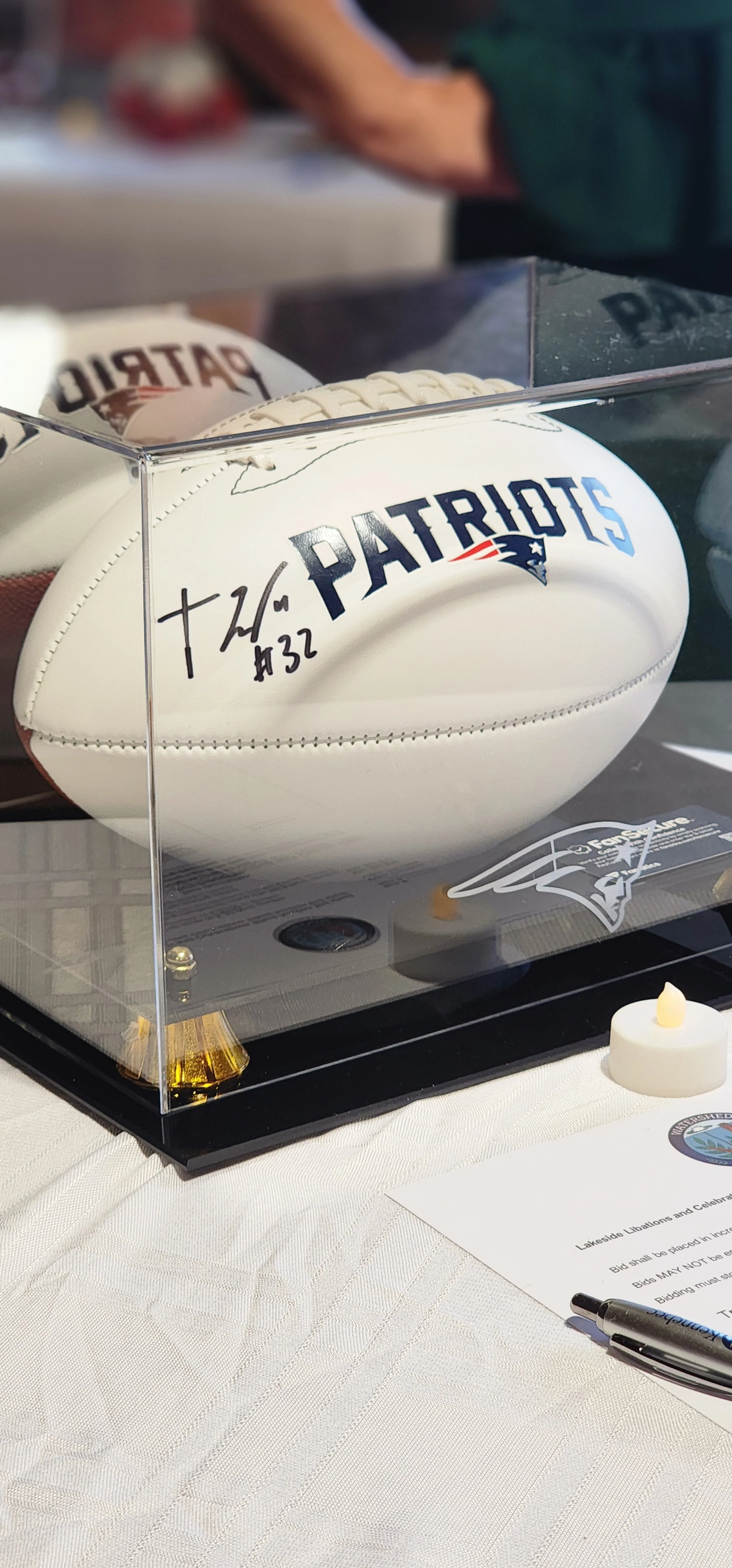 A signed Patriots football in a glass case