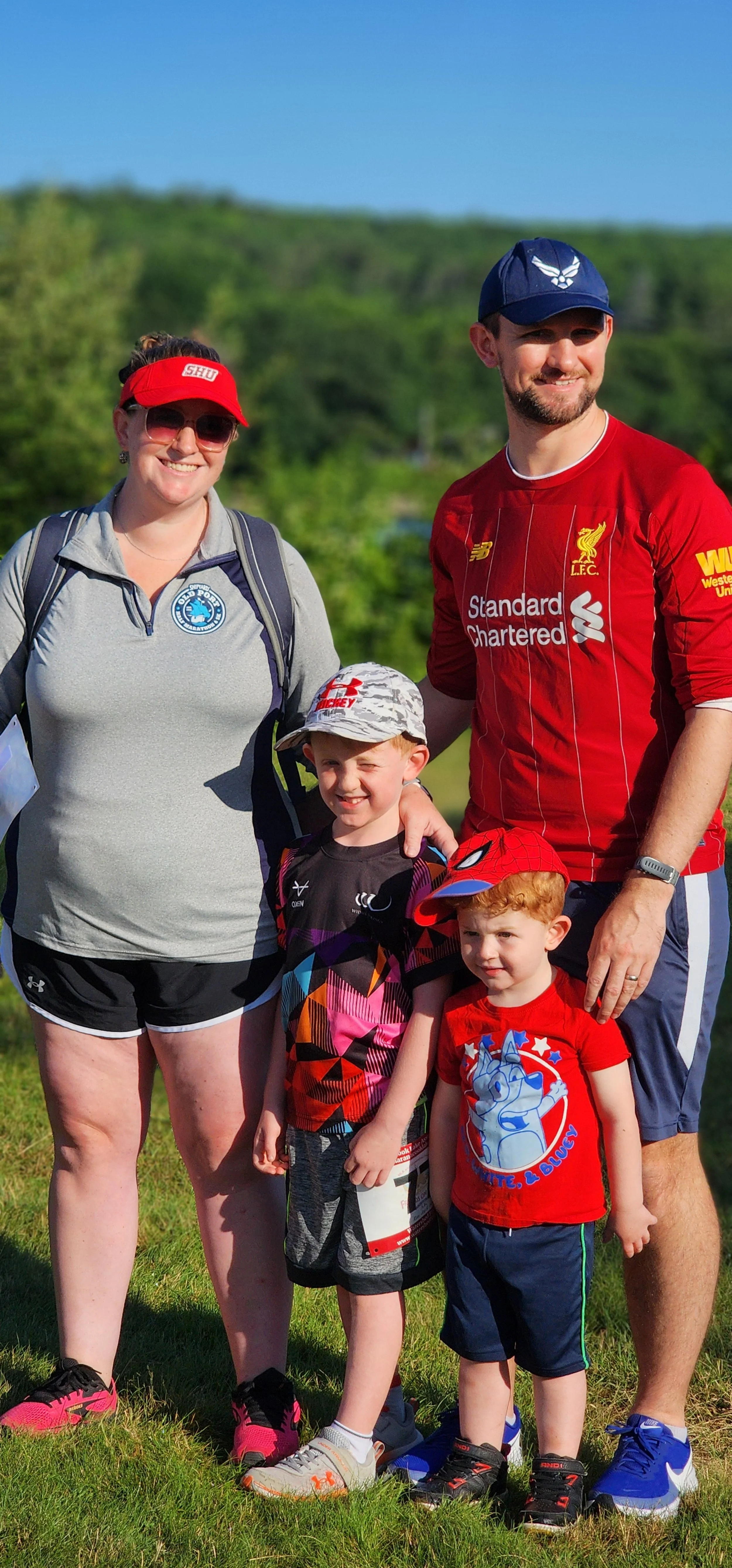 Four people, a woman, and man and two children, smiling at the camera