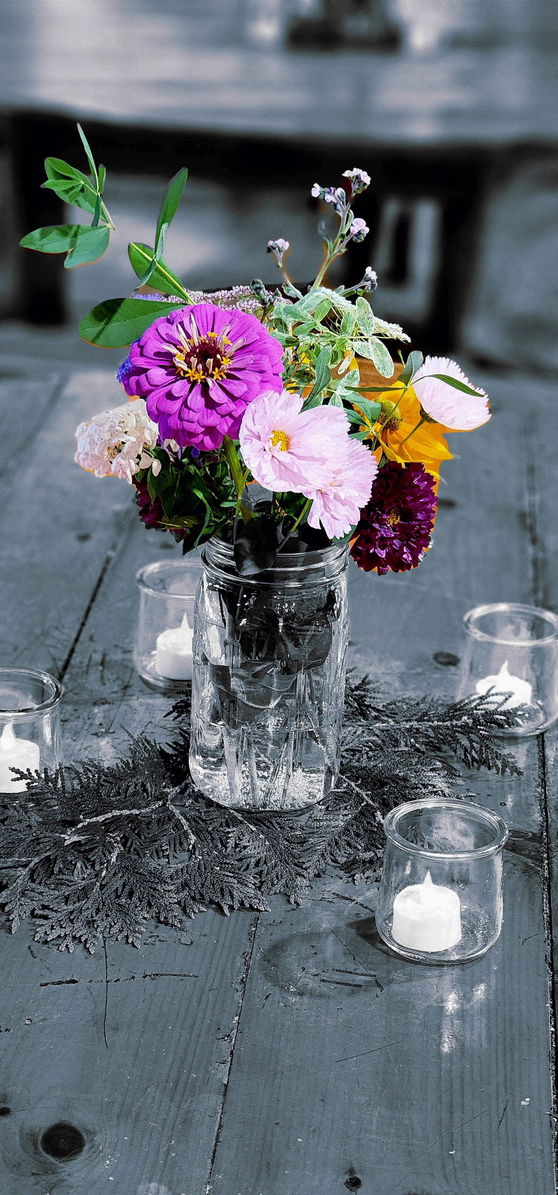 A vase of flowers, the flowers have the only color everything else has been edited to grey scale