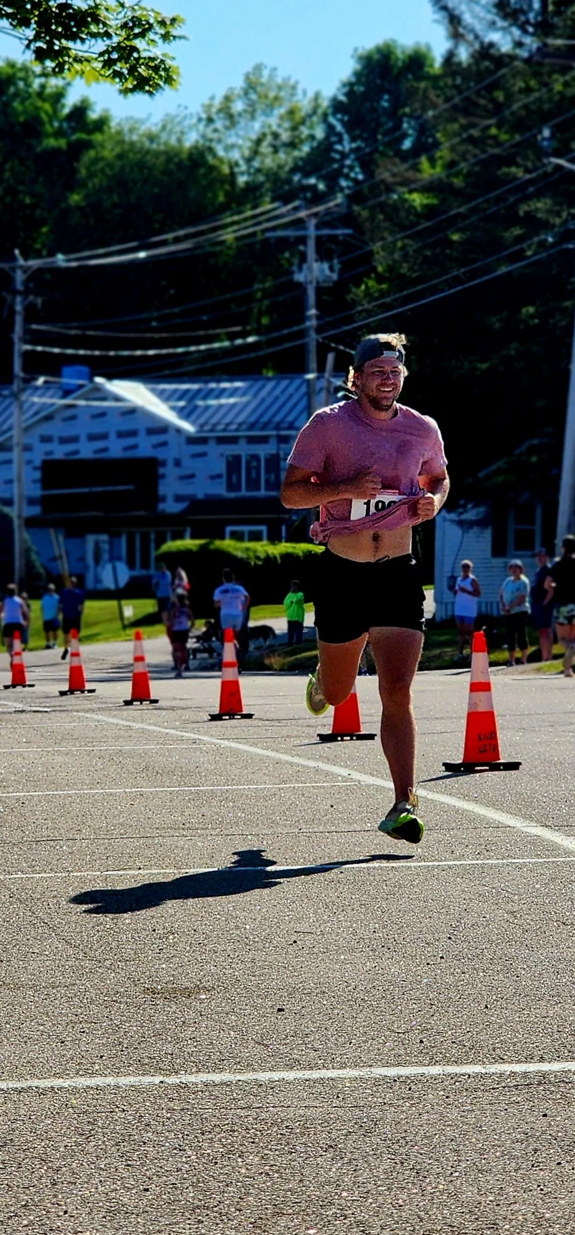A man wearing a pink t-shirt and black shorts running