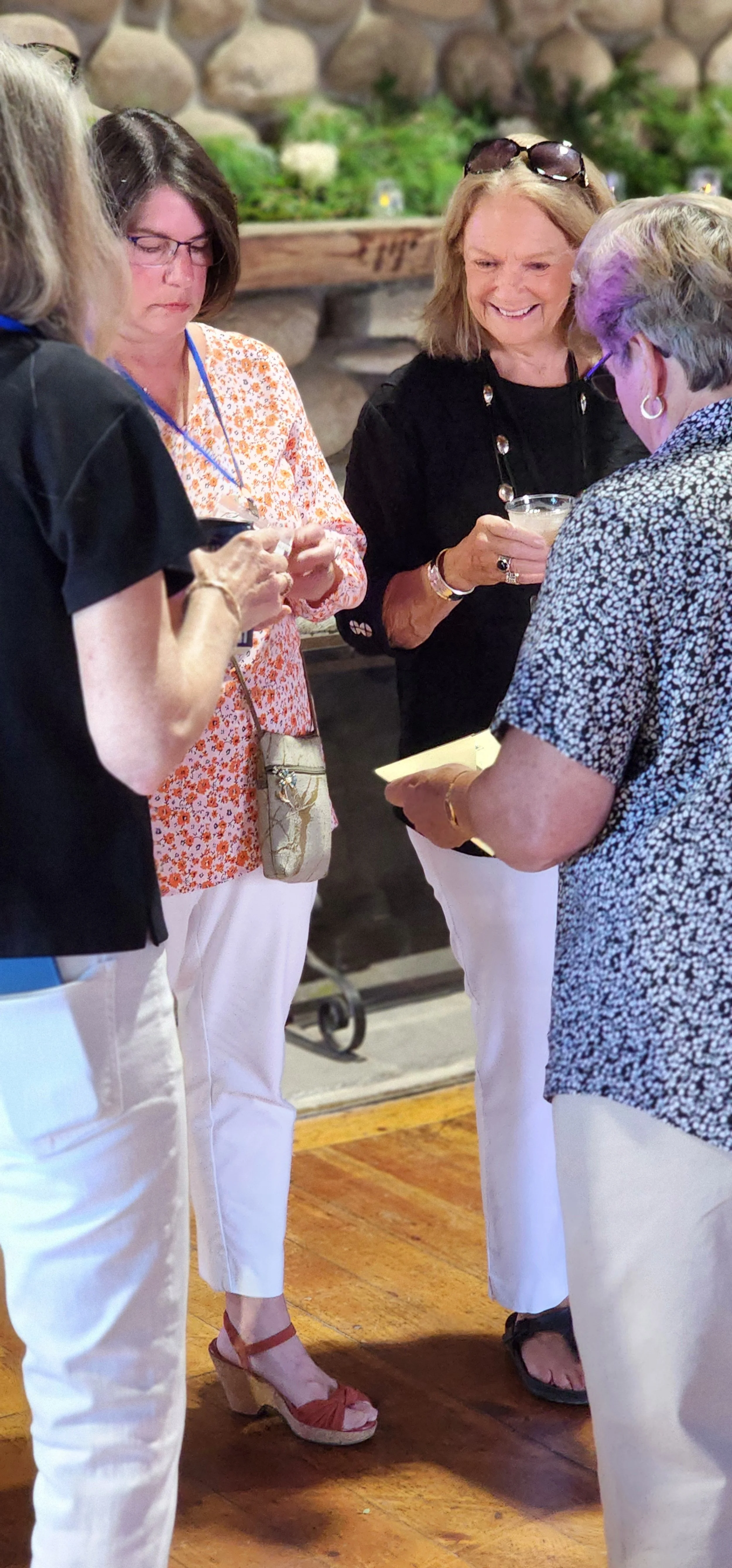 Four people gathered in a circle in front of a fireplace mantle