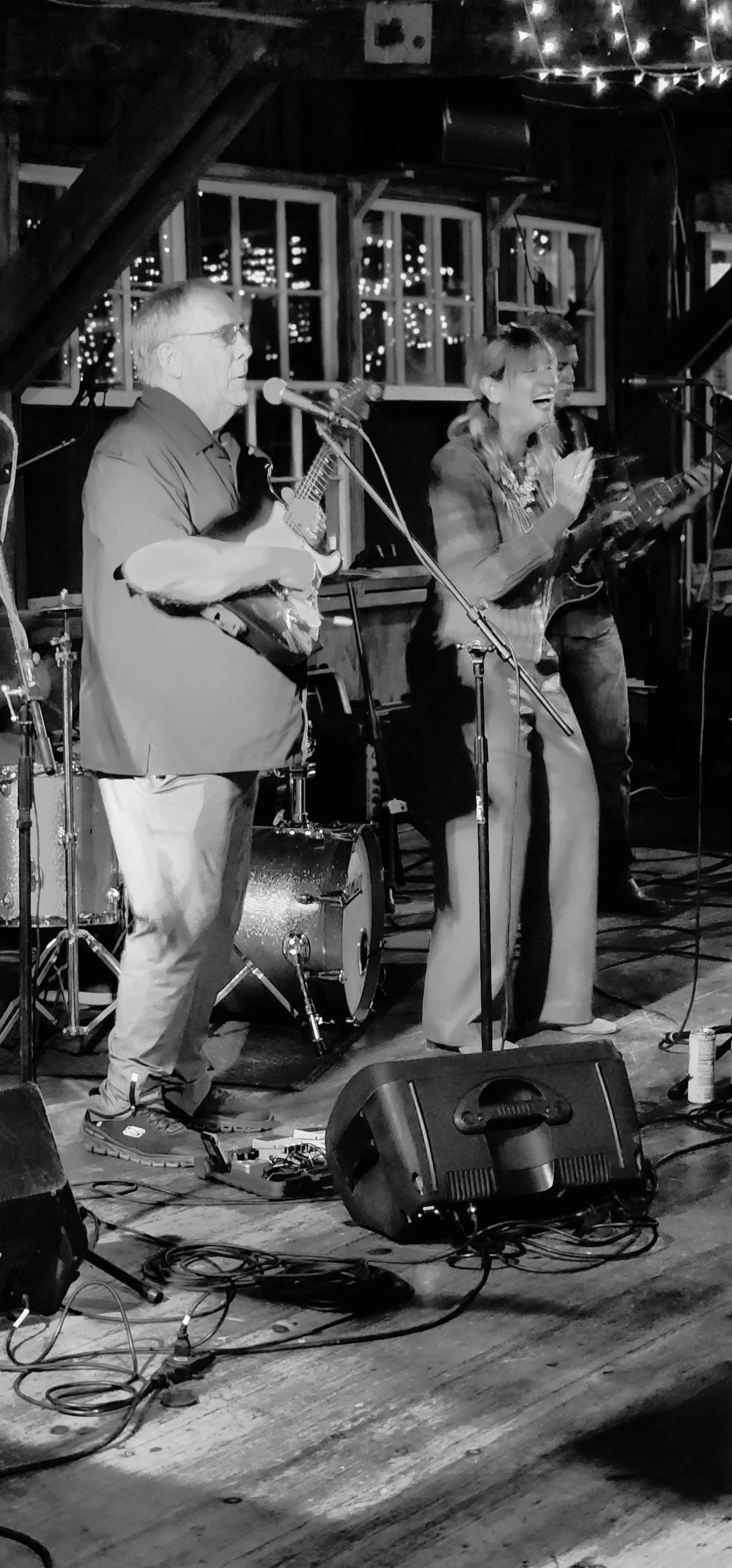 A man playing guitar and a woman singing into a microphone