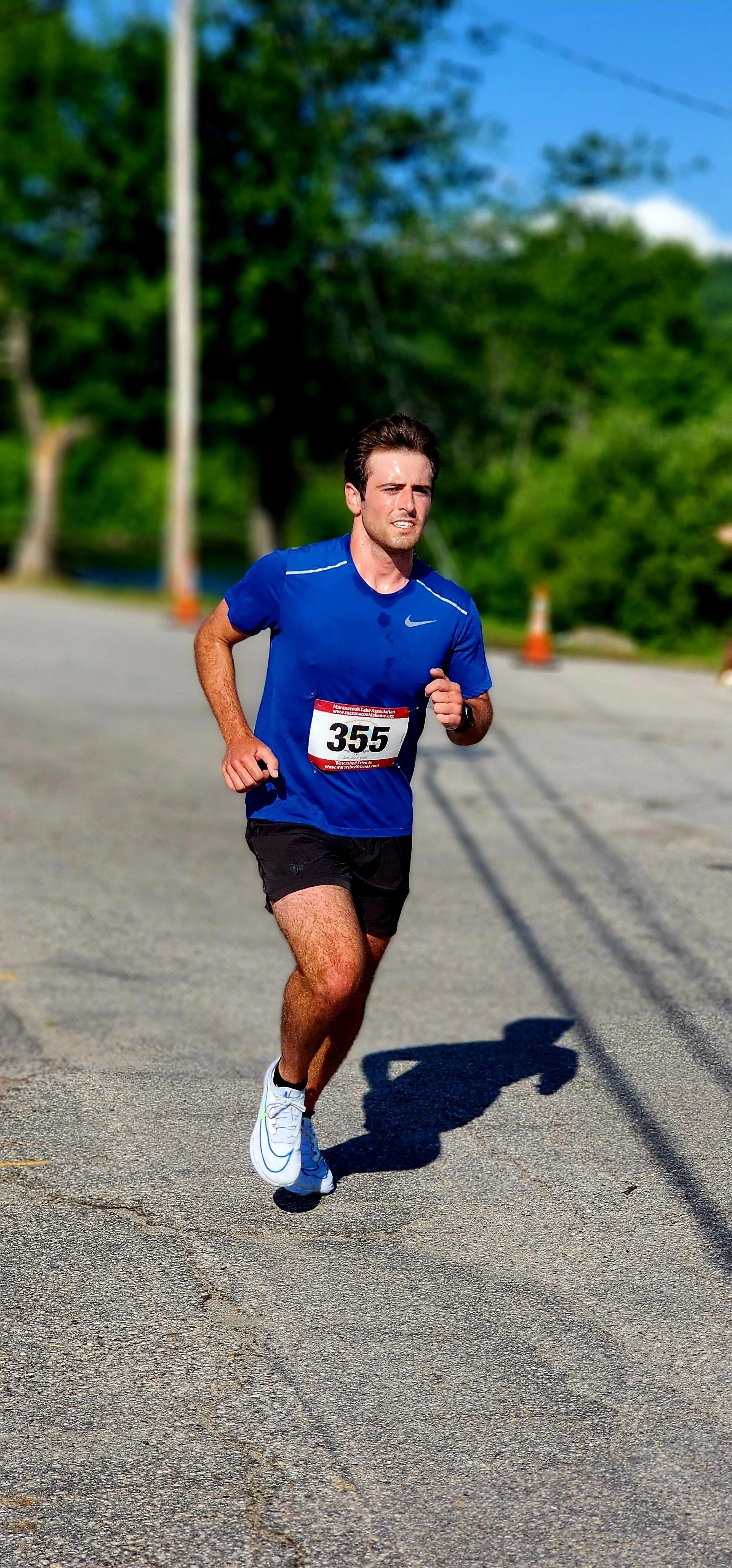 A man, wearing a blue t-shirt with black shorts, running