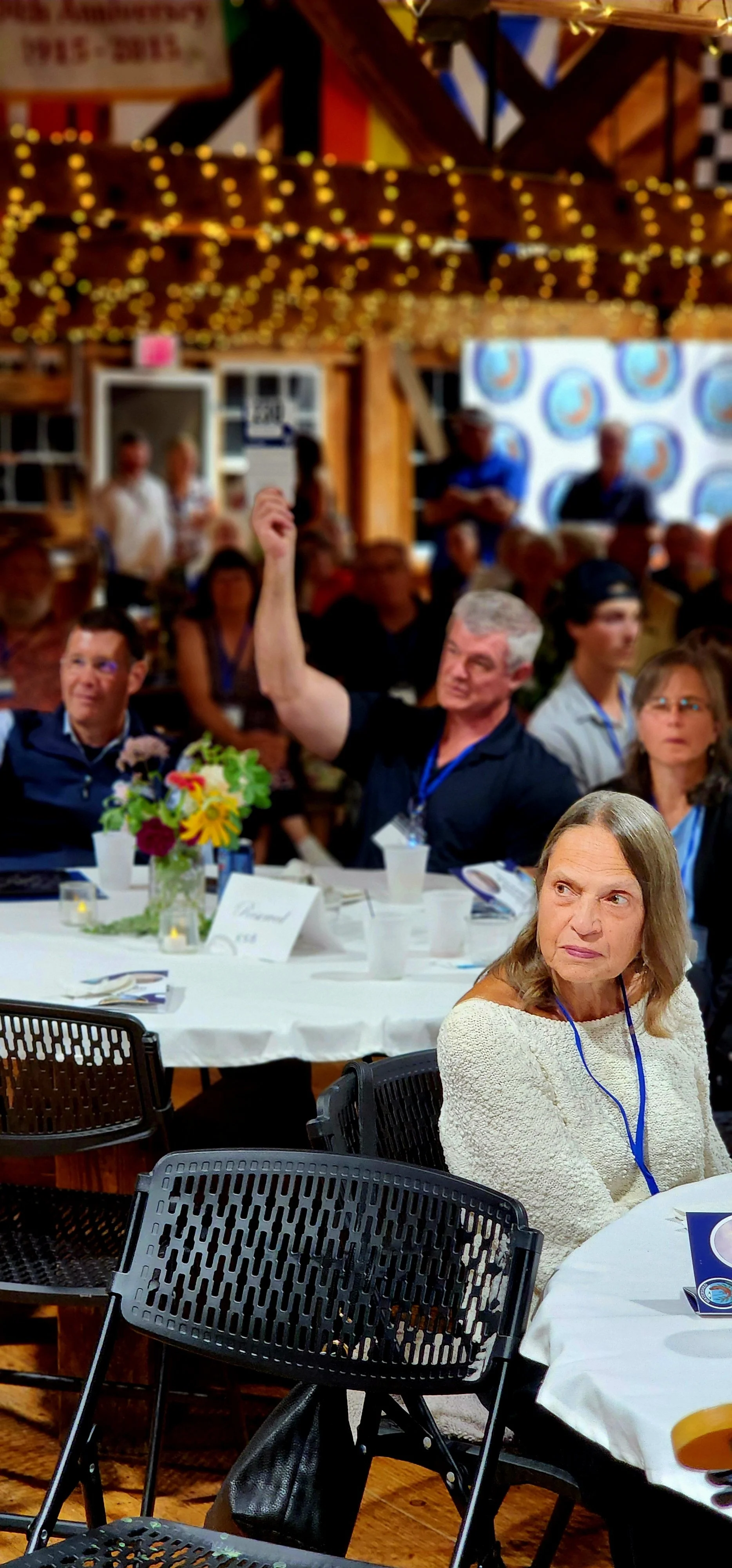 People sitting at tables watching something off camera