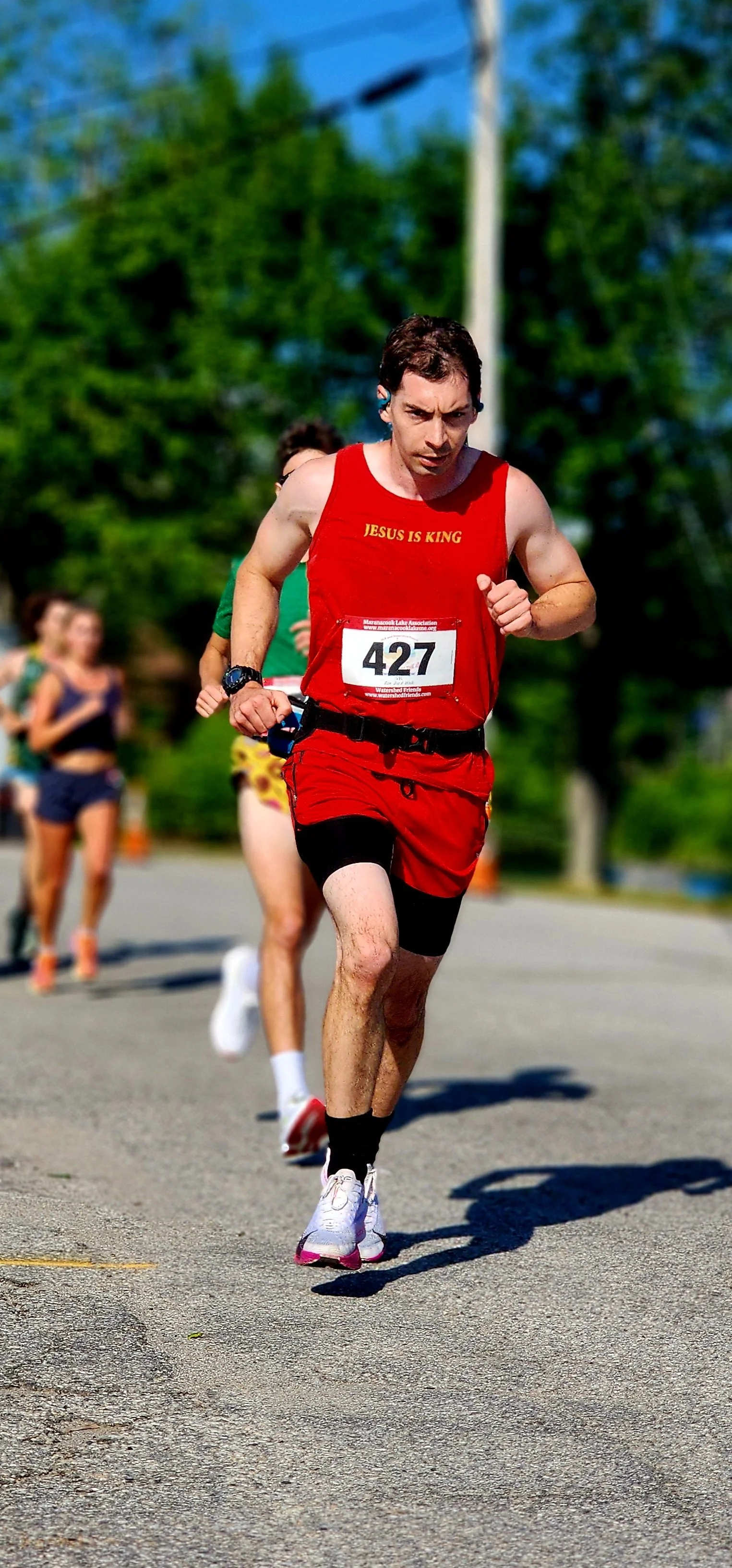 A man in a red tank top and red shorts running