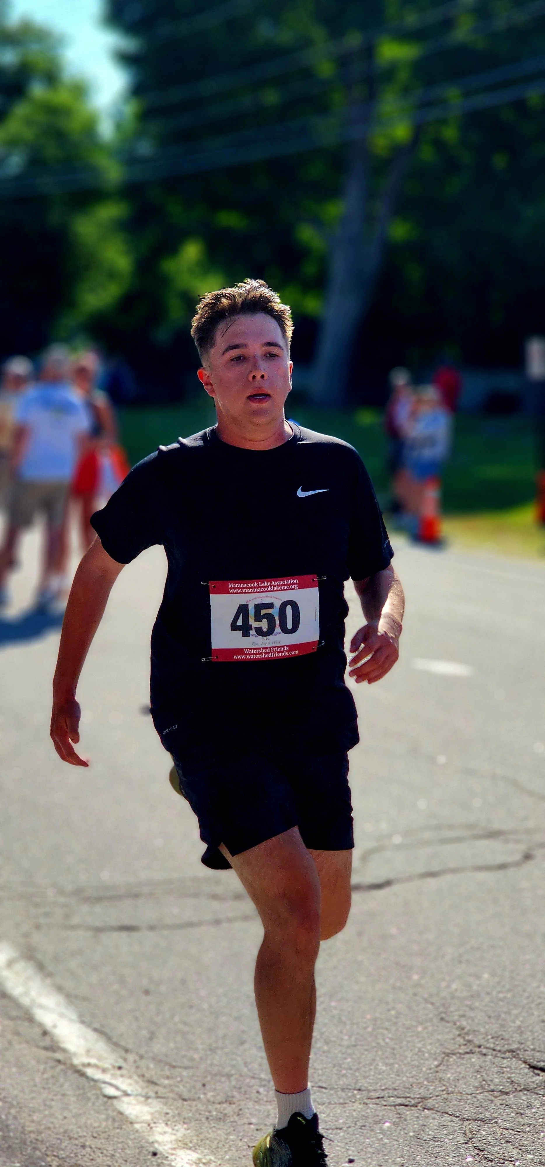 A man wearing a black t-shirt and shorts running