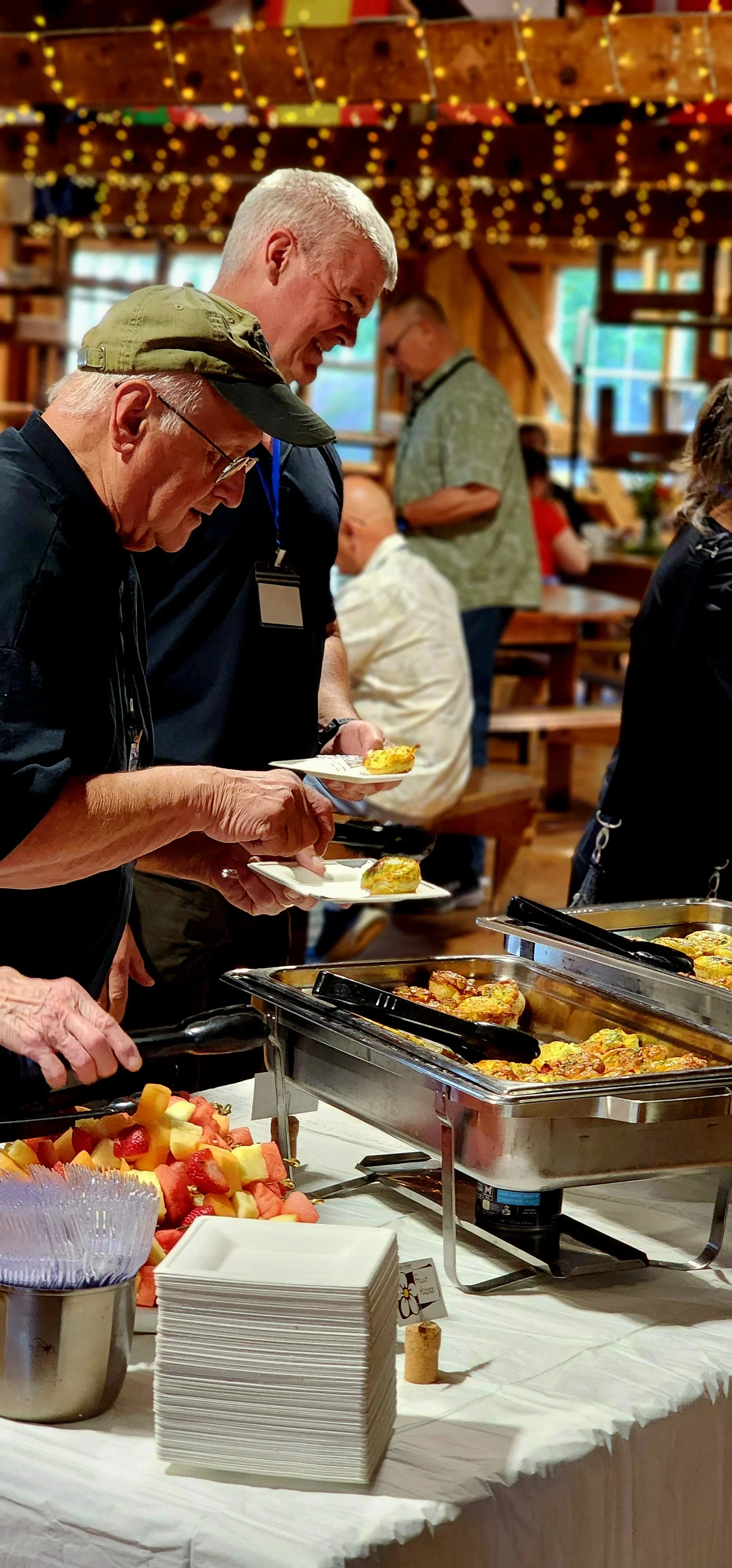People taking food from a buffet table