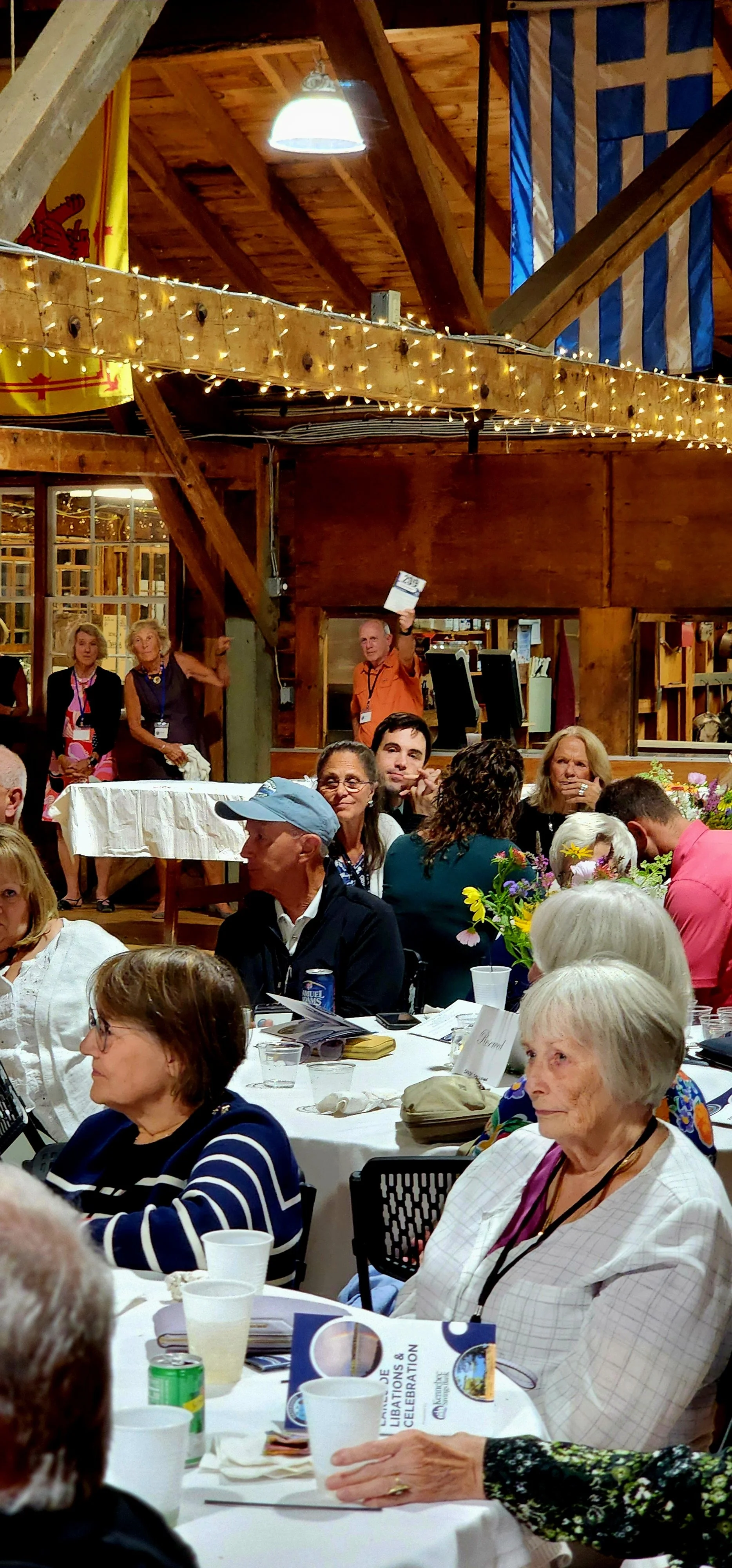People sitting at tables watching something off camera