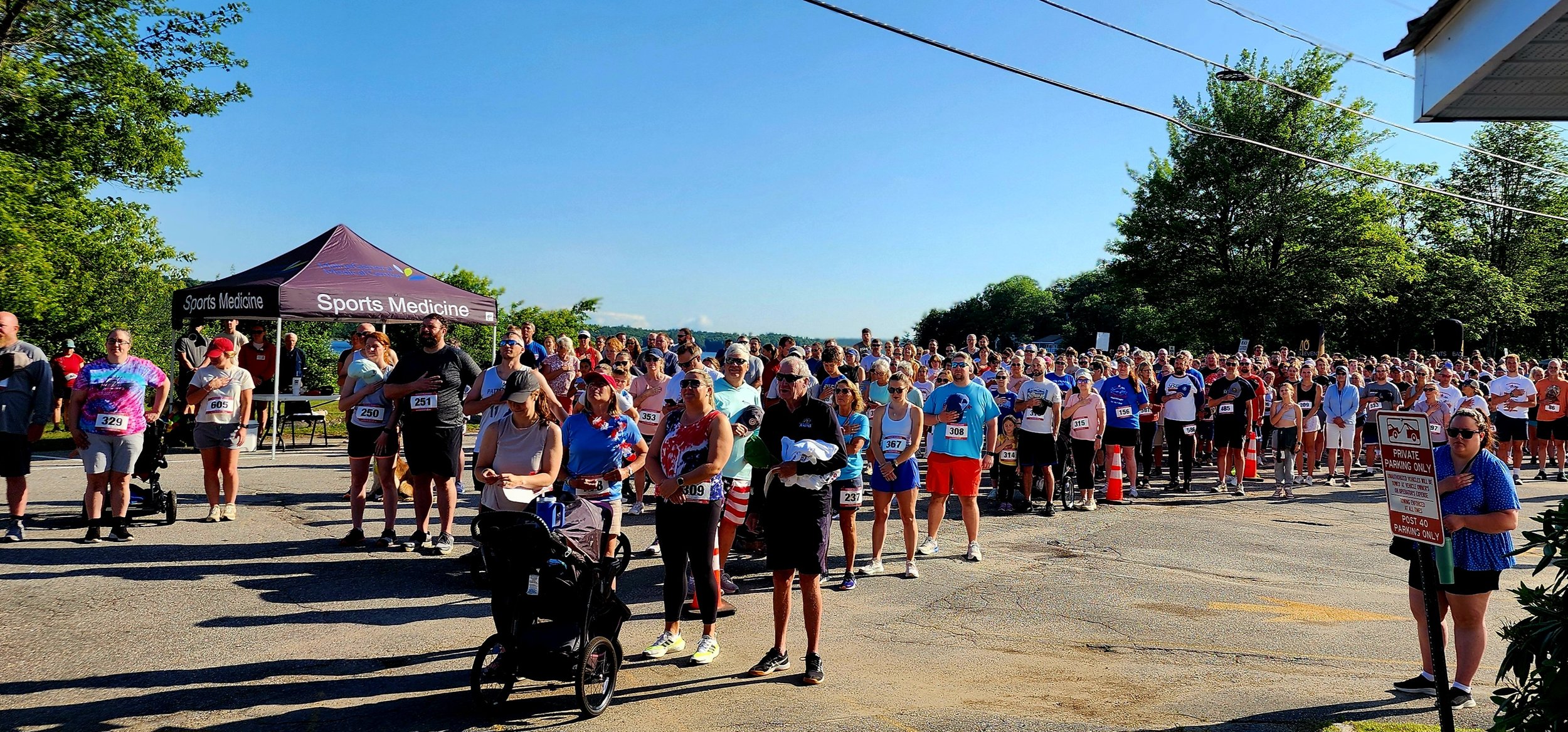 A crowd standing for the national anthem